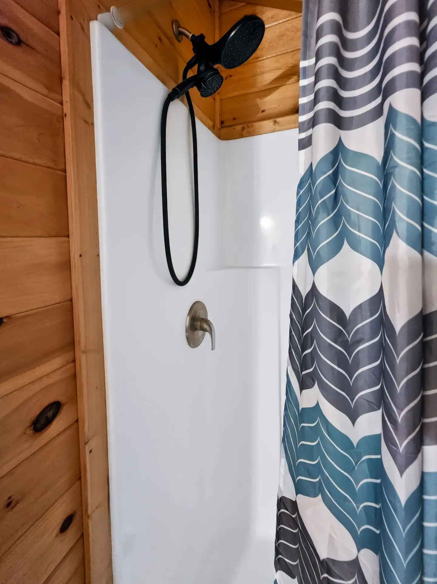 Walk-in shower with patterned curtain in the bathroom at Buckeye Hut cabin