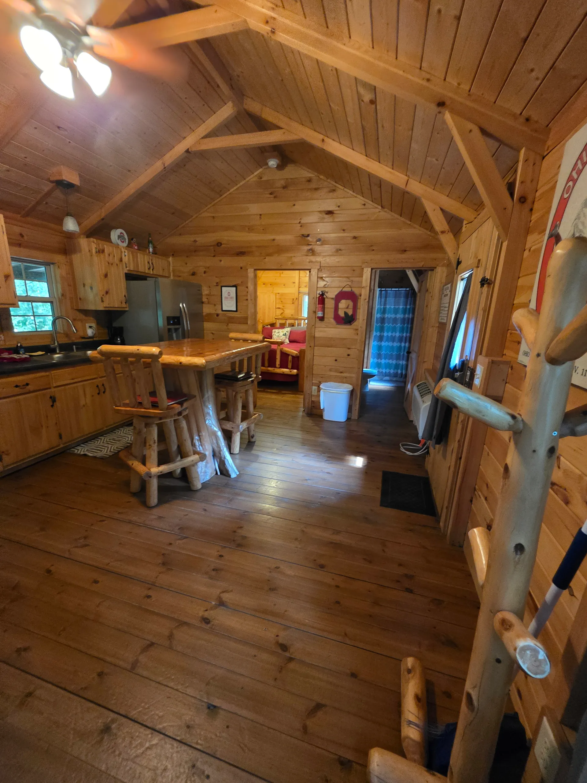 View from loft down to living room, kitchen, and bedroom showing full A-frame interior at Buckeye Hut cabin