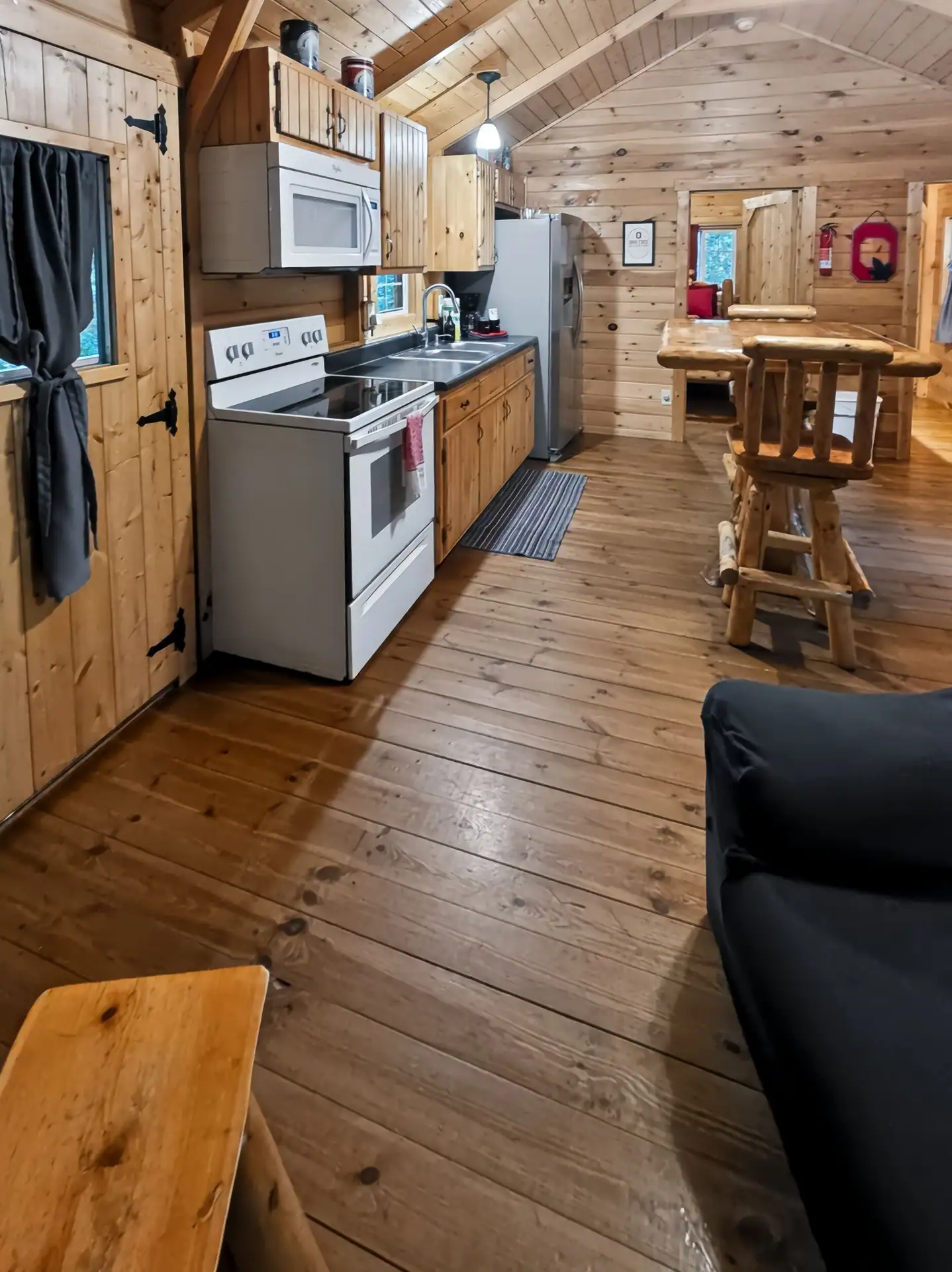 Full kitchen with pine cabinets, stove, microwave, and refrigerator at Buckeye Hut cabin