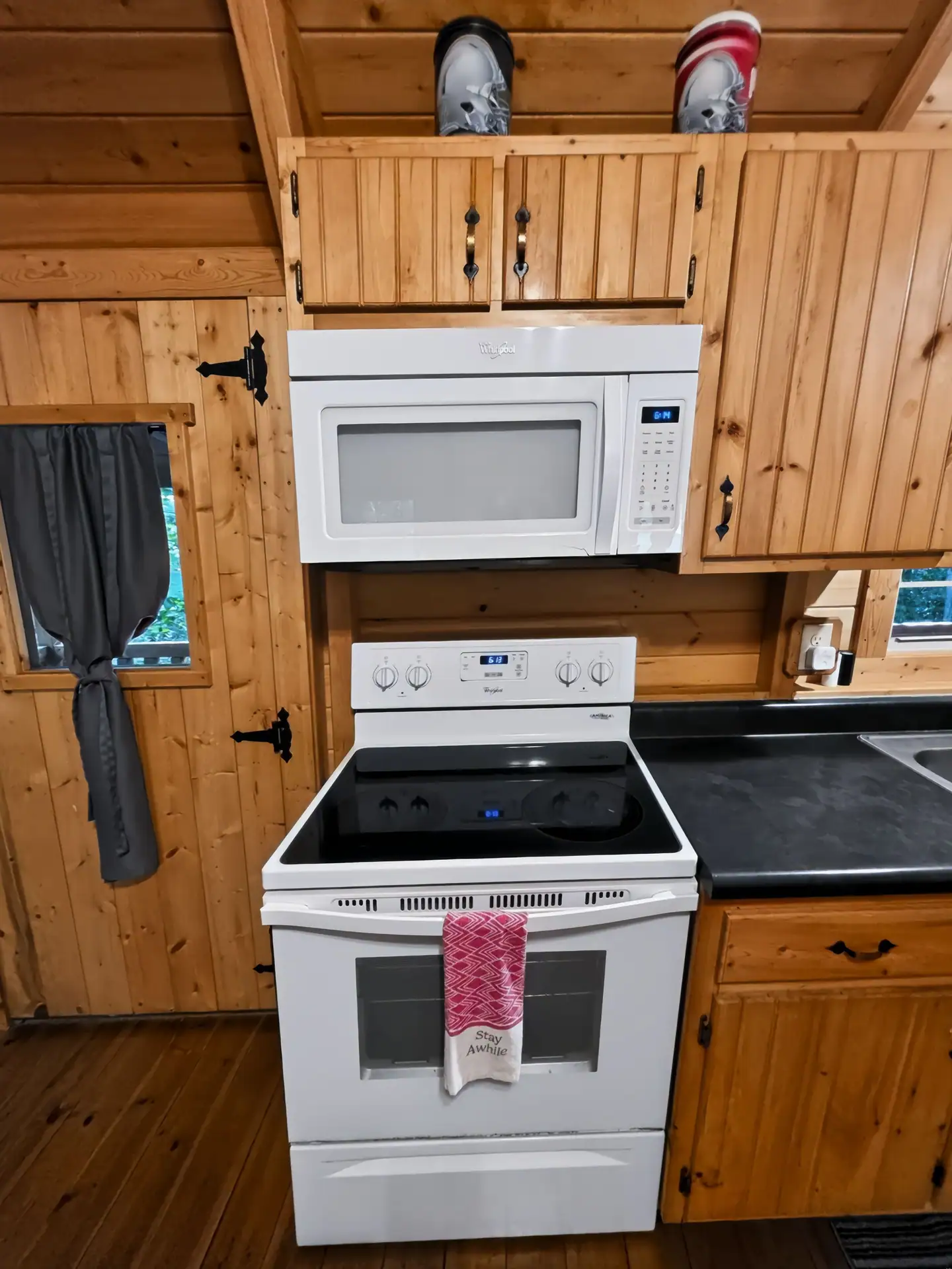 Electric stove and microwave under pine cabinets in the kitchen at Buckeye Hut cabin
