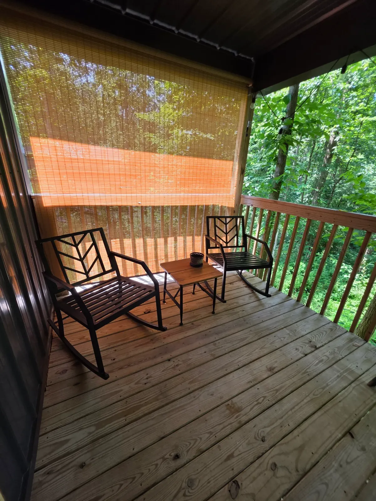 Deck seating area with metal chairs overlooking the wooded property at Butterfly Ridge cabin