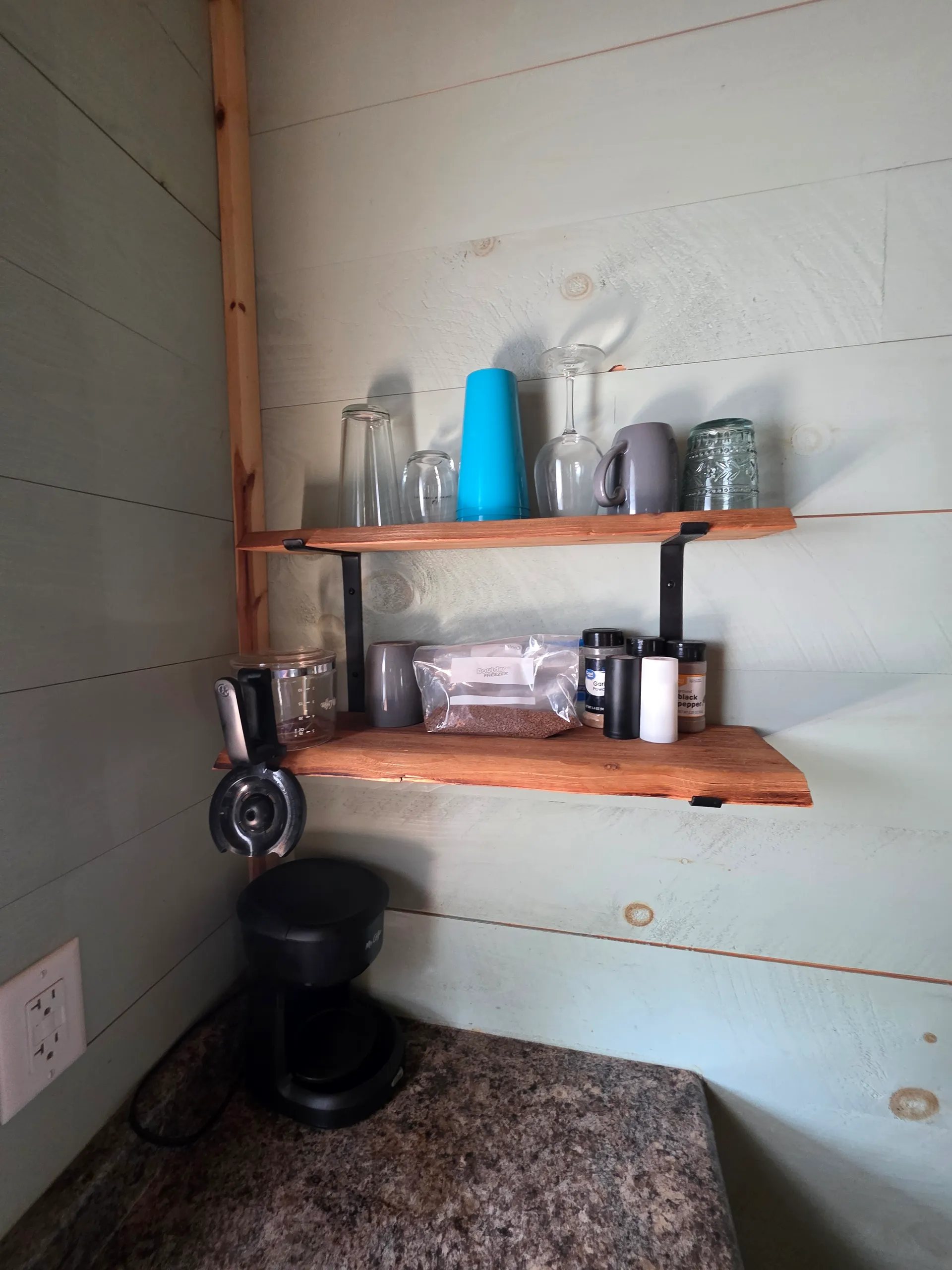 Floating wood shelves with glassware and small plants on shiplap wall at Butterfly Ridge cabin