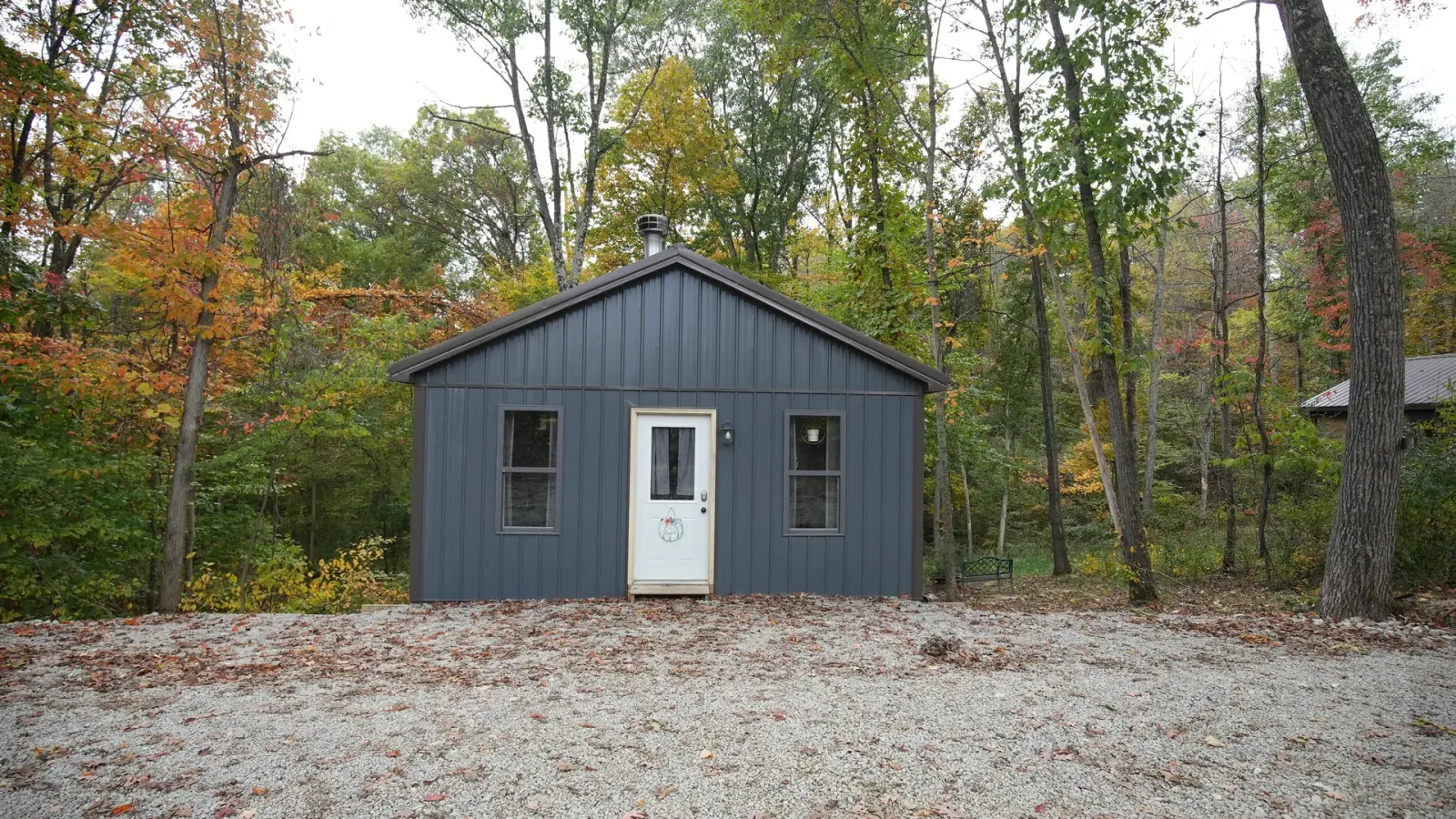 Butterfly Ridge cabin front exterior with dark siding among autumn foliage