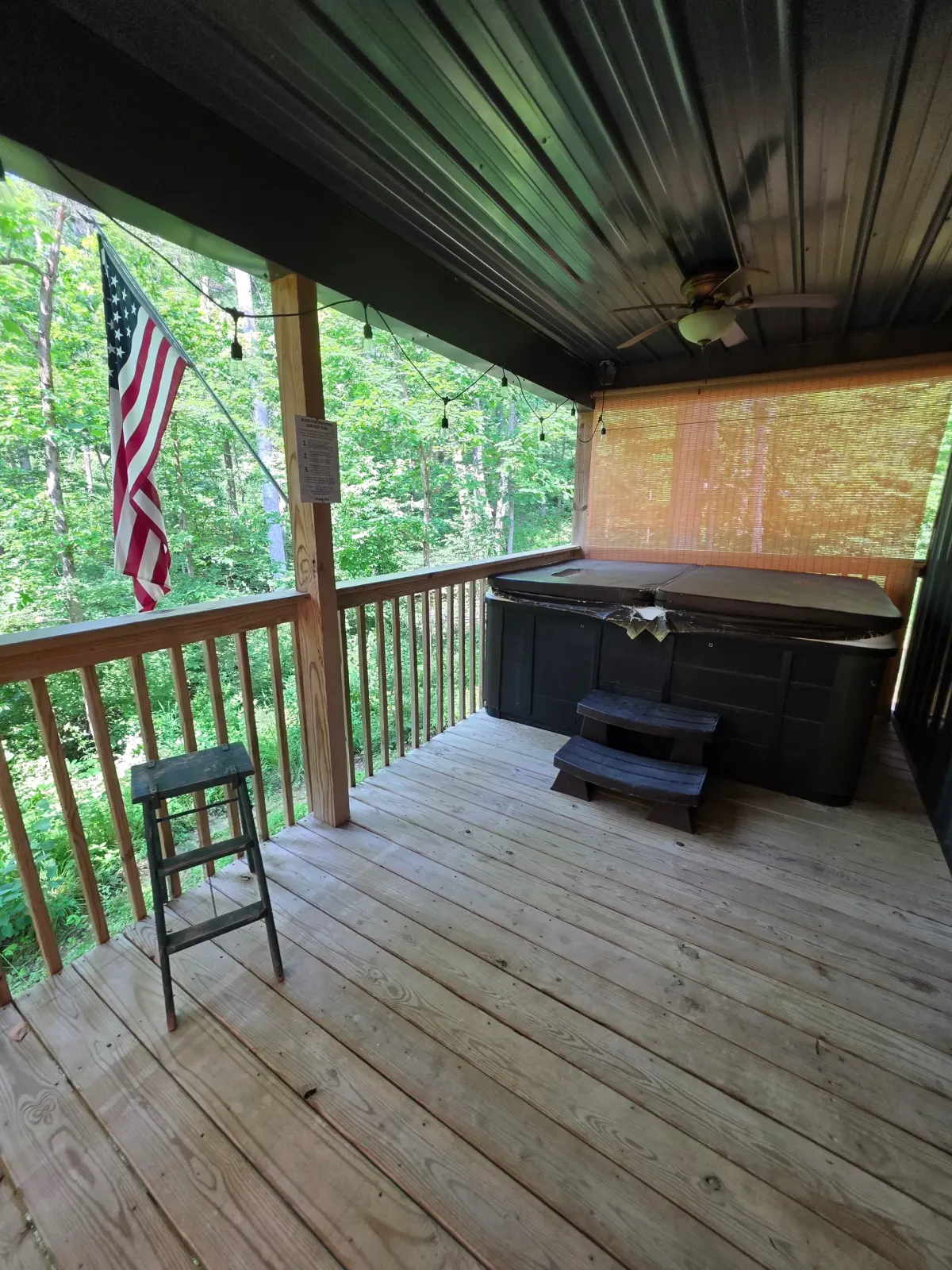 Fire pit area with charcoal grill and seating in the wooded yard at Butterfly Ridge cabin