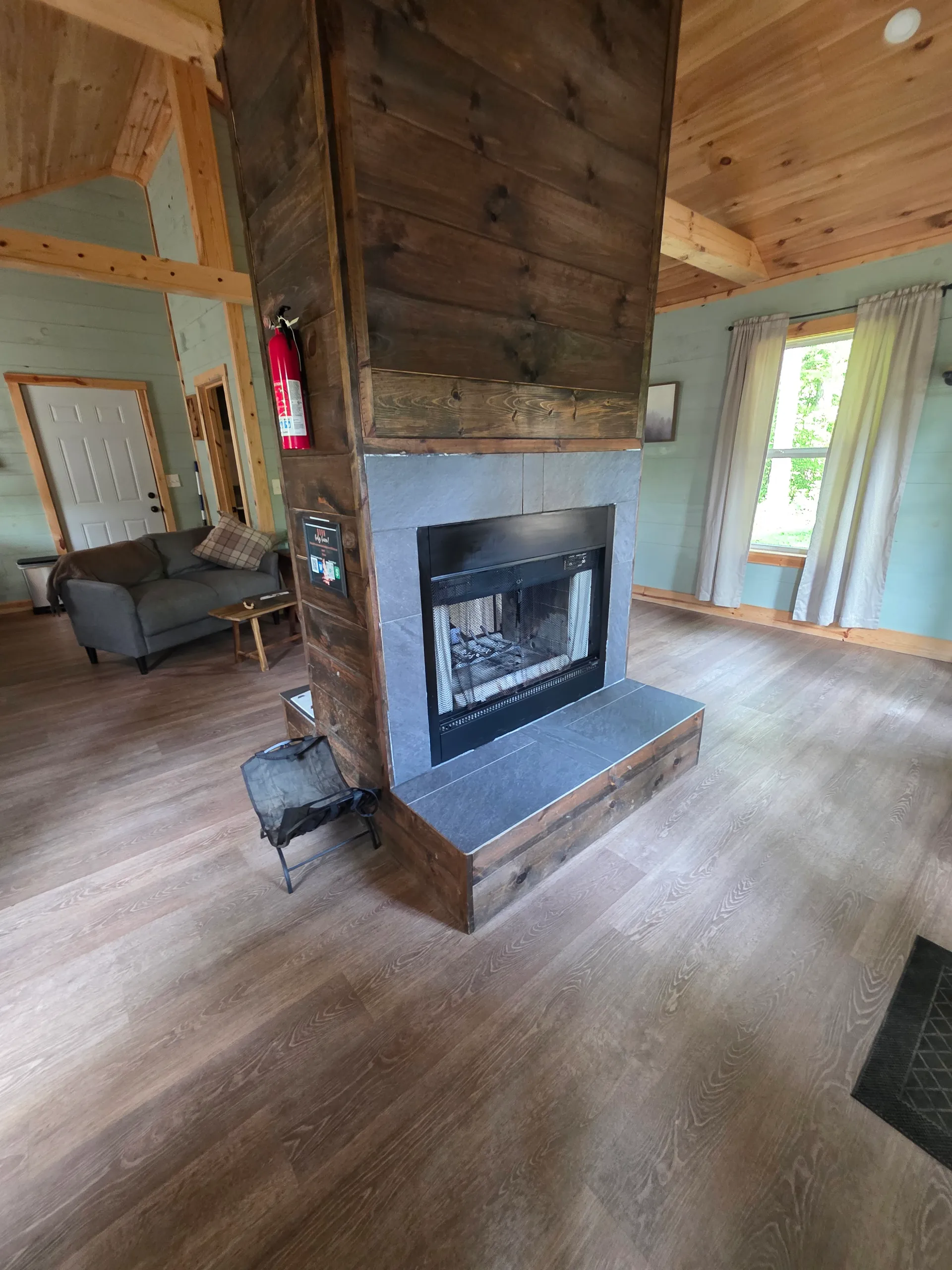 Double-sided cedar fireplace with stone accent and wall-mounted TV in the living room at Butterfly Ridge cabin