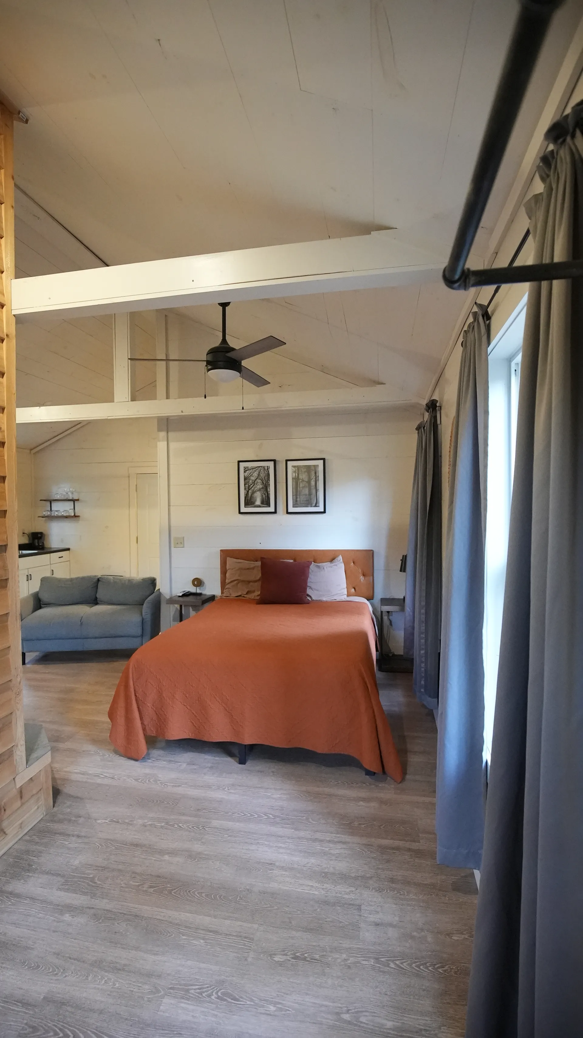 Kitchenette with white cabinets, black countertop, sink, and window at Butterfly Ridge cabin