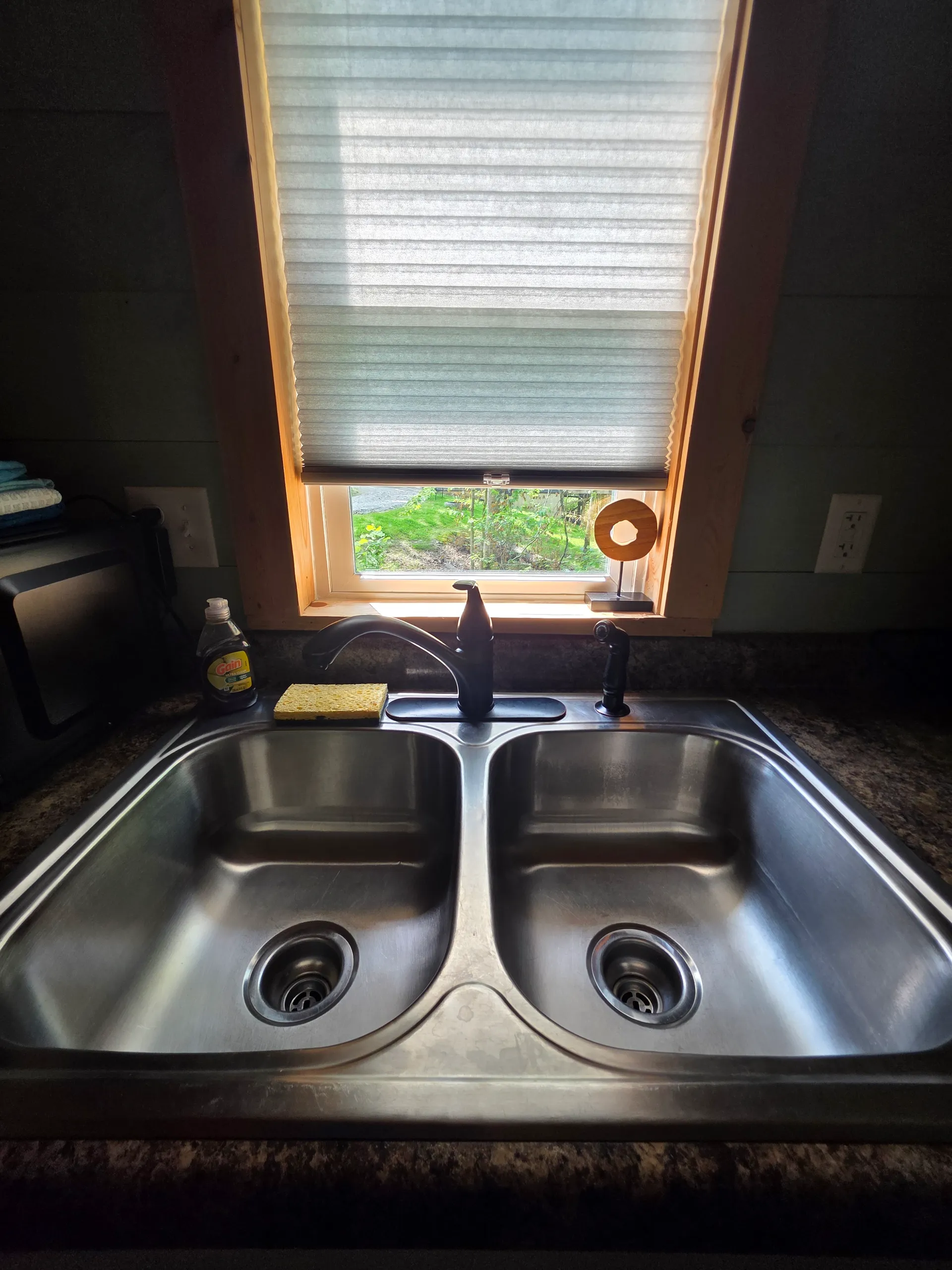Kitchenette sink area with black faucet, white cabinets, and window view at Butterfly Ridge cabin