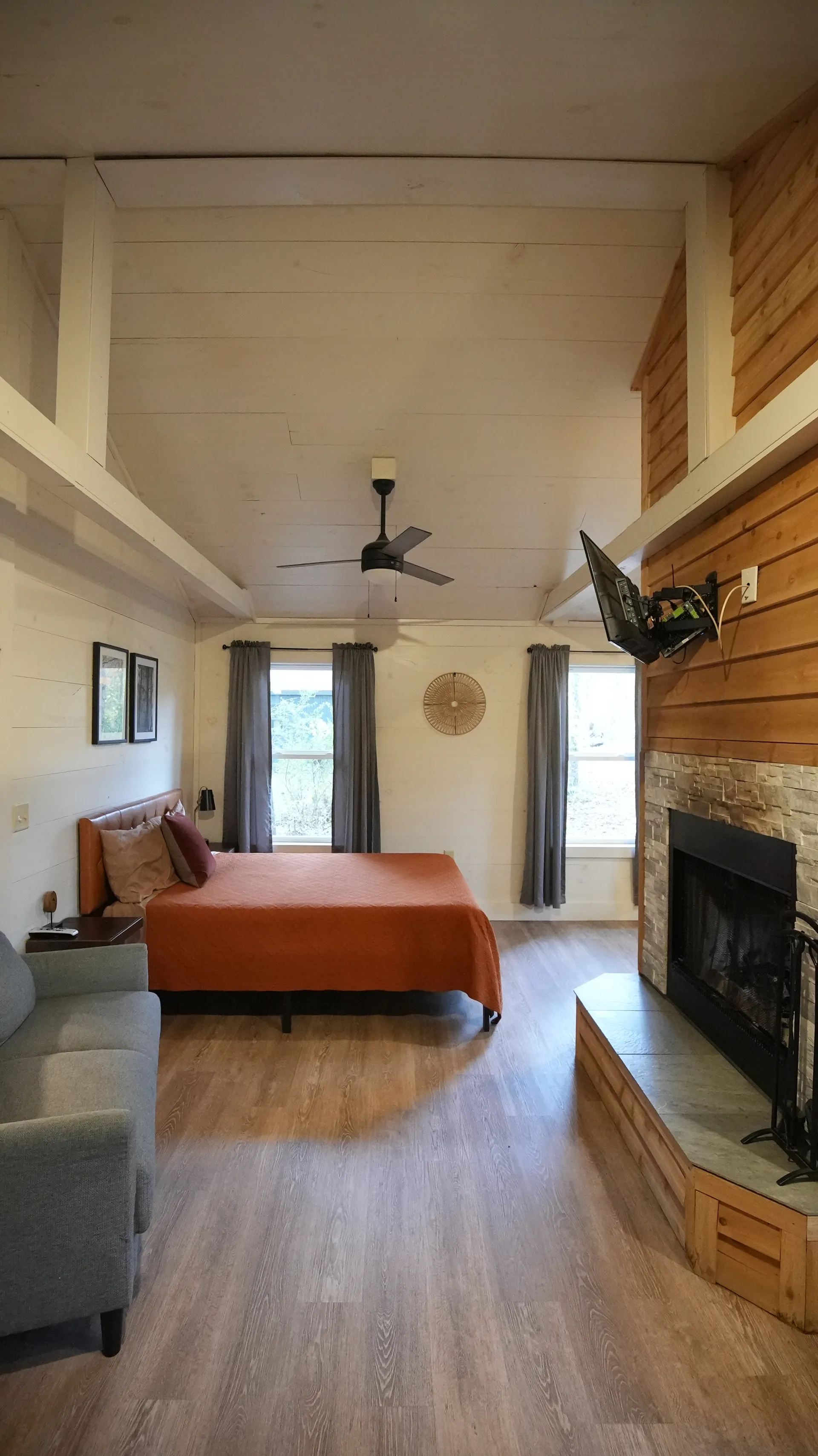 Living room with gray sofa, fireplace, and vaulted ceiling at Butterfly Ridge cabin
