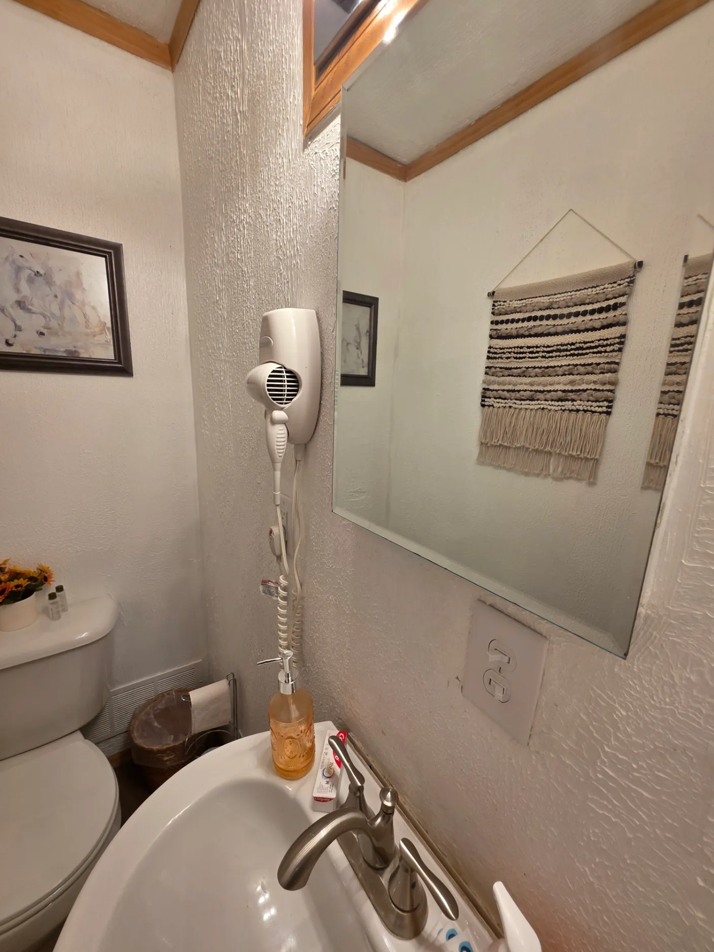 Bathroom shower area with wall-mounted showerhead and macrame hanging at Cherokee Way cabin