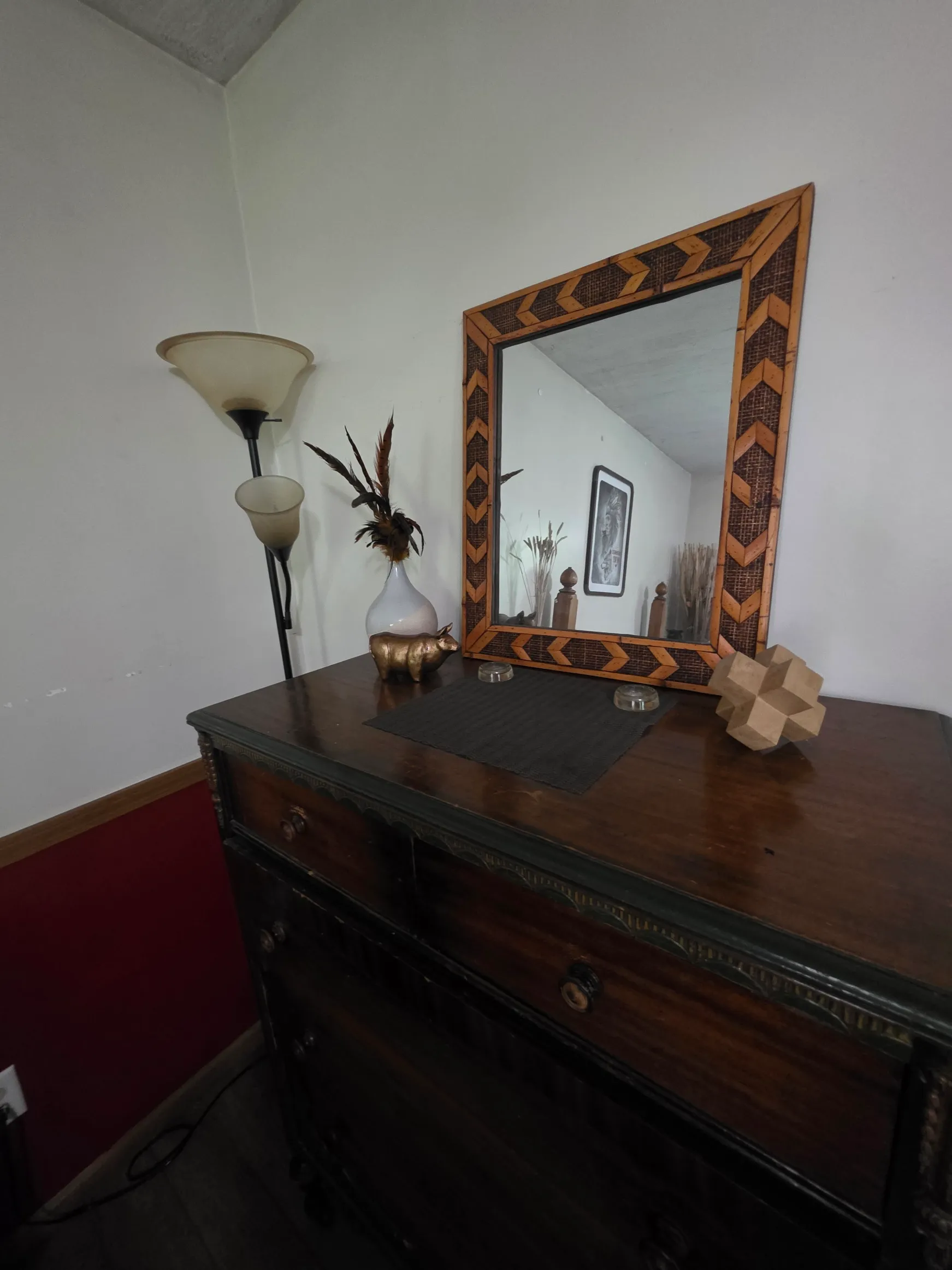 Bedroom dresser with chevron-patterned mirror and decorative lamp at Cherokee Way cabin