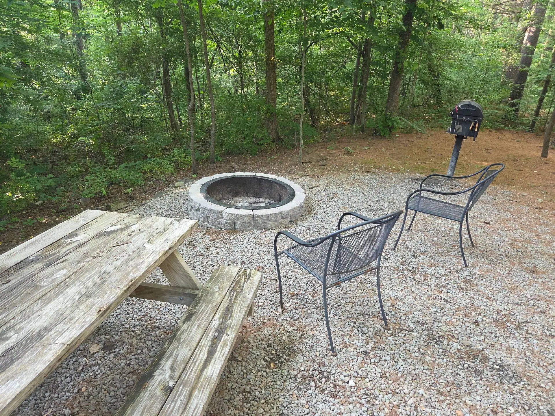 Fire pit with two metal chairs next to the picnic table at Cherokee Way cabin