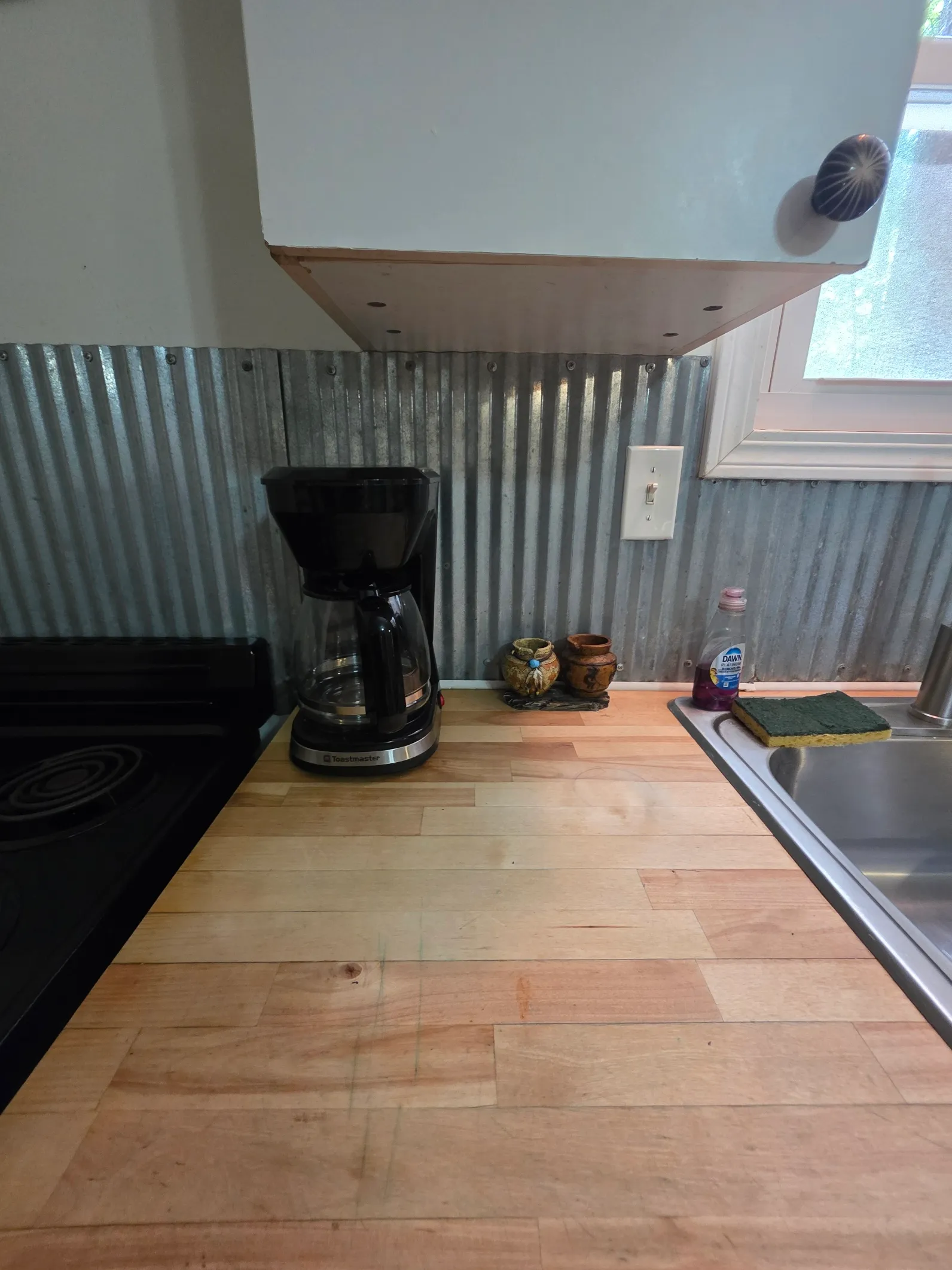 Kitchenette counter with coffee maker and corrugated metal backsplash at Cherokee Way cabin