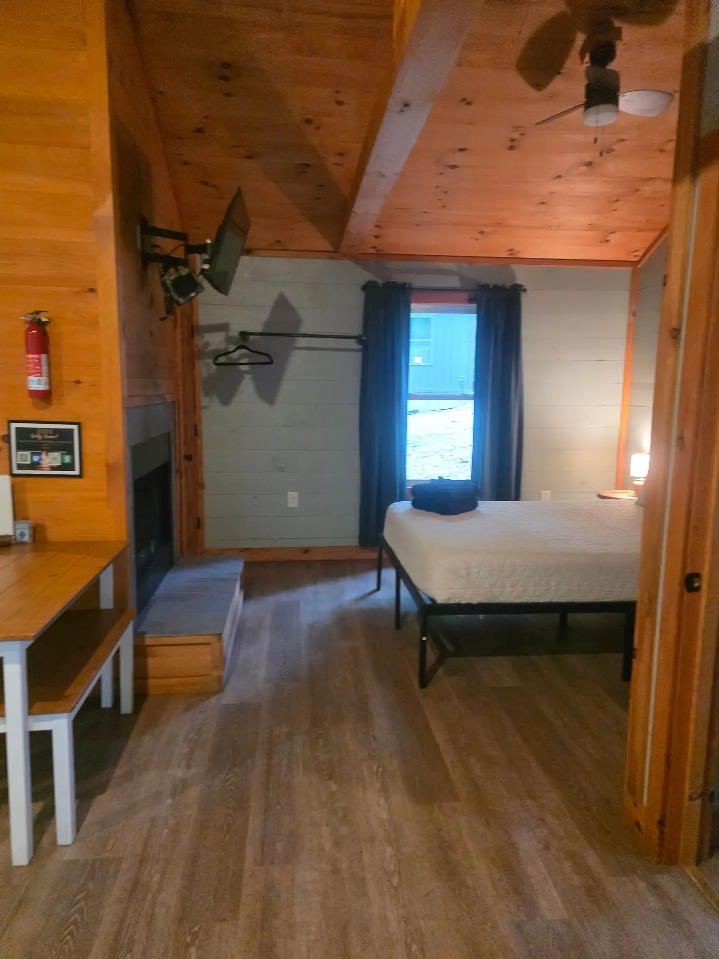 Bedroom area with queen bed next to the fireplace wall at Dogwood Run cabin