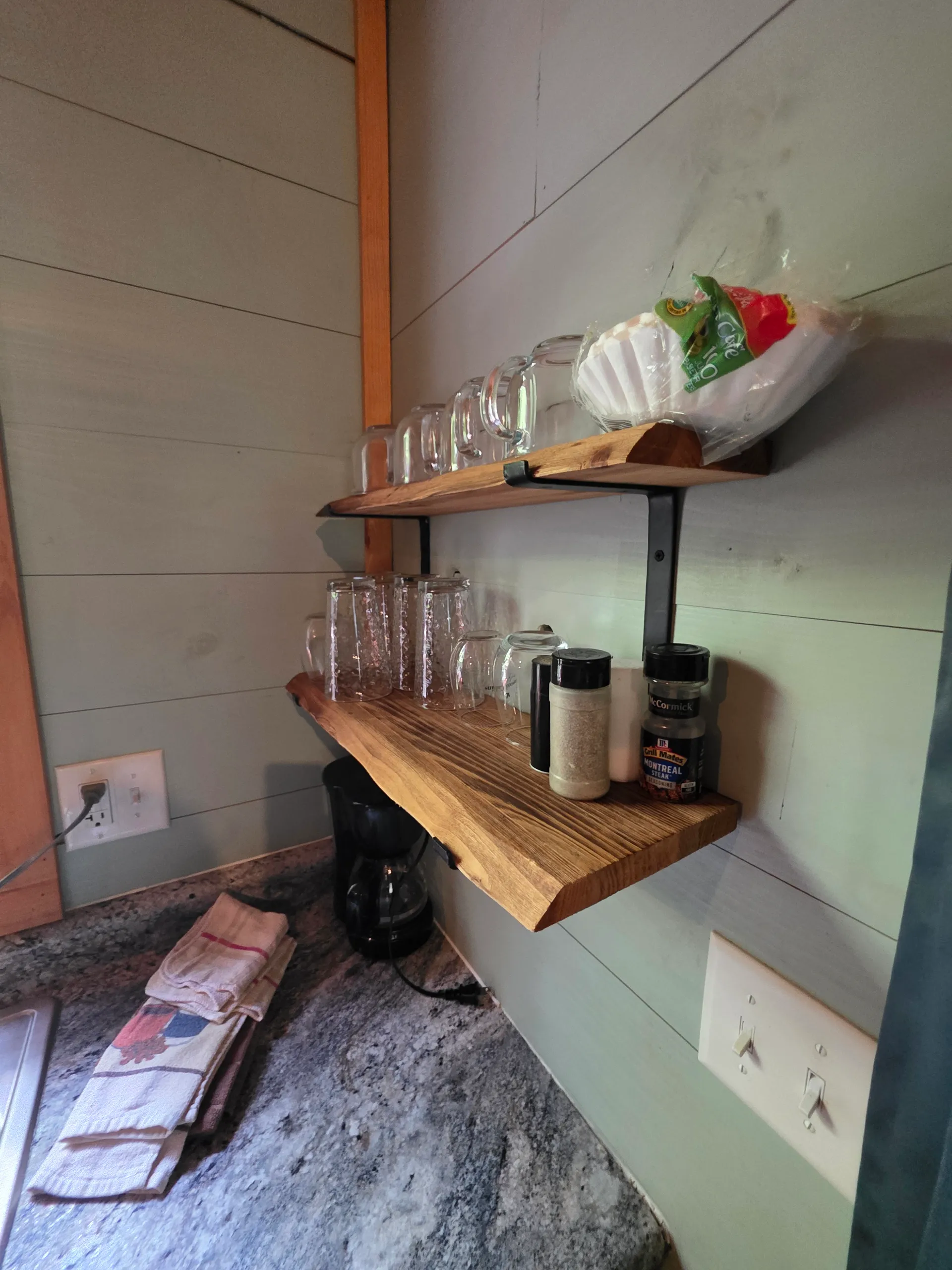 Open wood shelves with glasses, spices, and coffee maker in the kitchen at Dogwood Run cabin