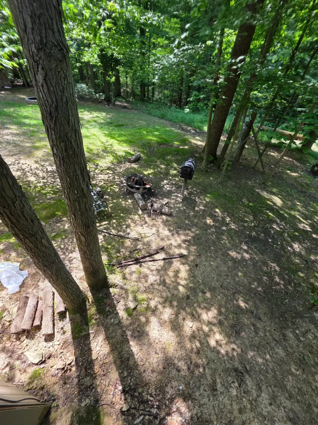 Fire pit and charcoal grill in the wooded yard at Dogwood Run cabin