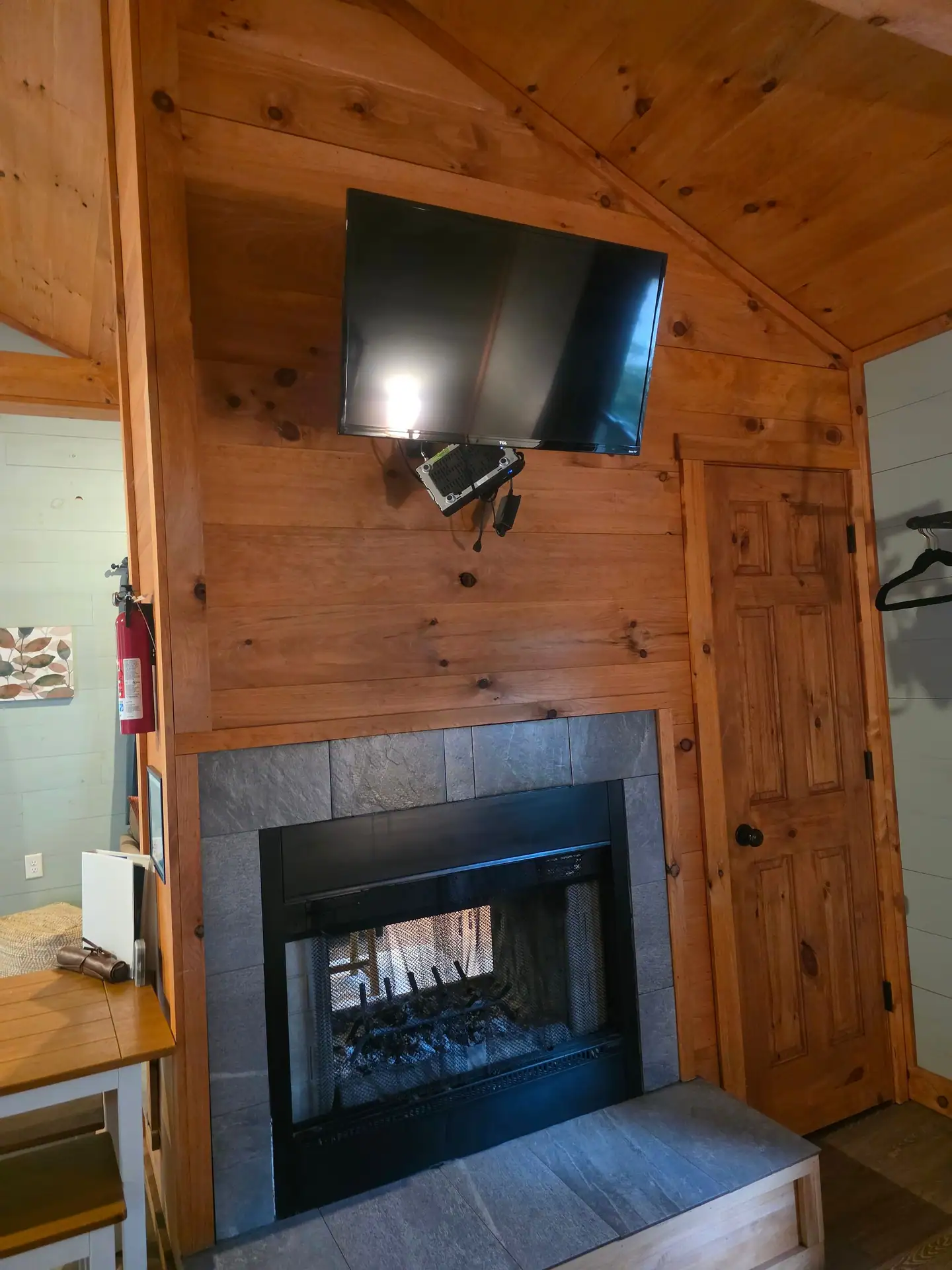 Bedroom side of the double-sided fireplace with a second TV above at Dogwood Run cabin