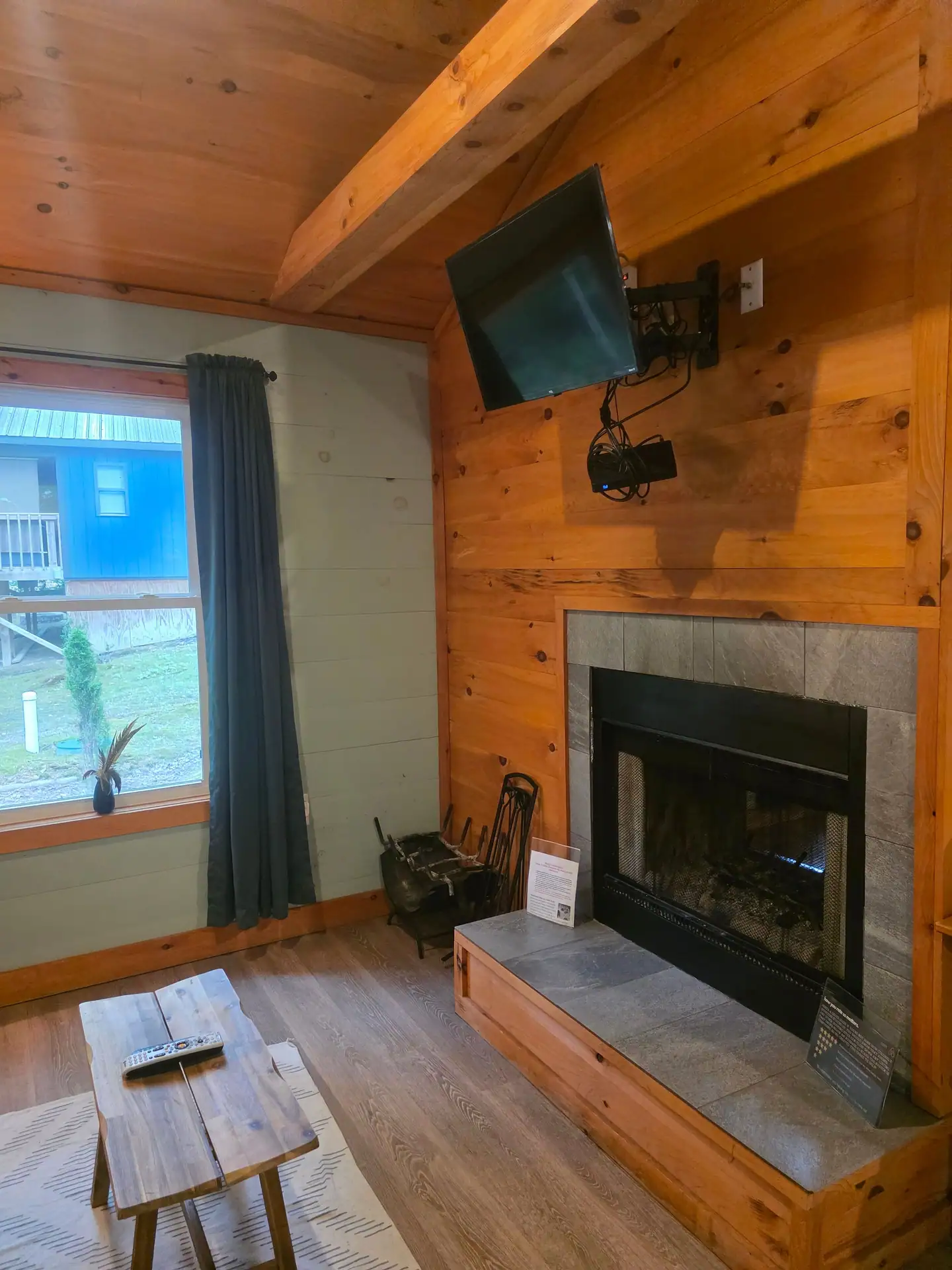 Wood-paneled fireplace wall with TV and slate hearth on the living room side at Dogwood Run cabin