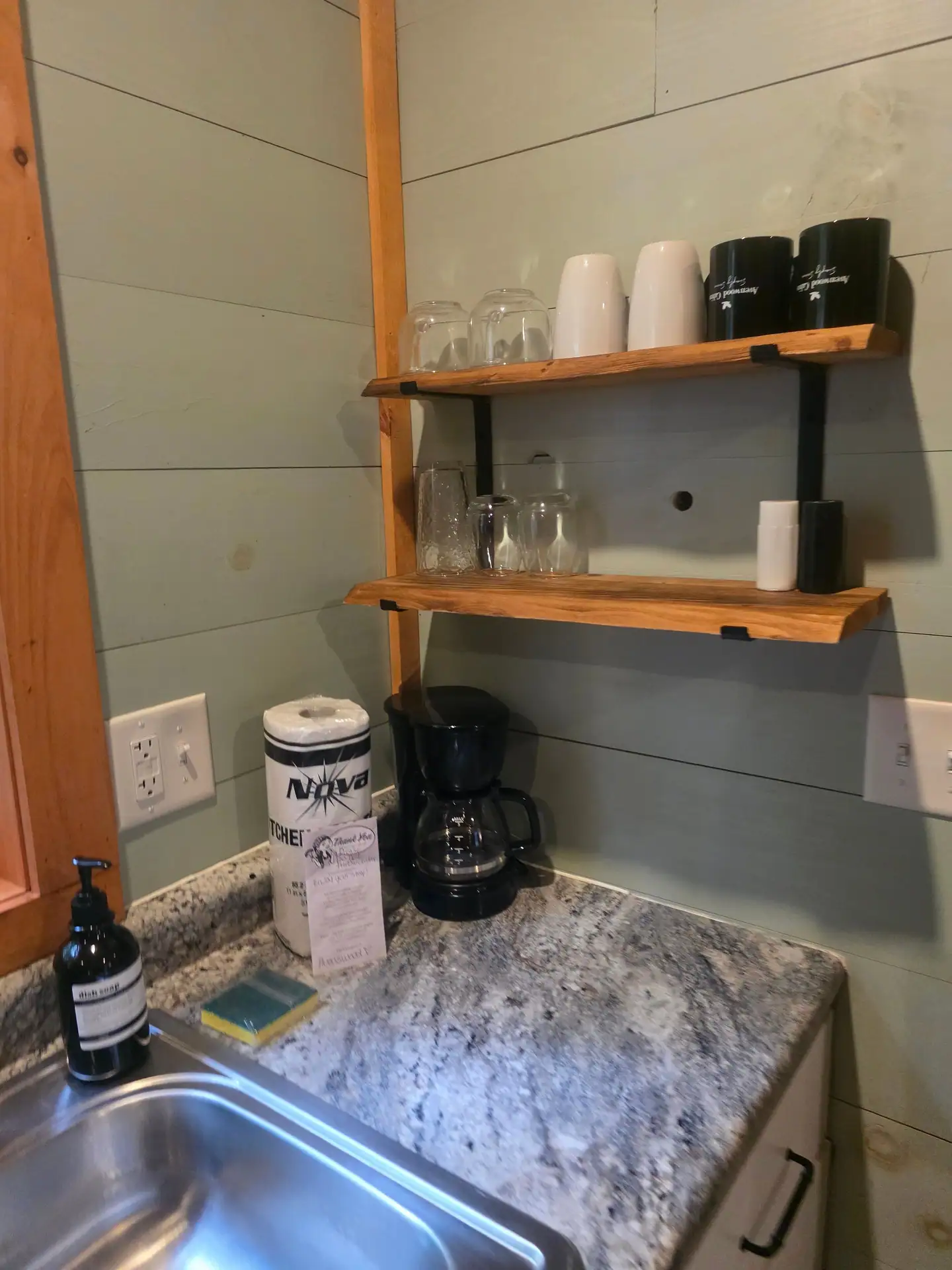 Open wood shelves with glasses and a coffee maker in the kitchenette at Dogwood Run cabin