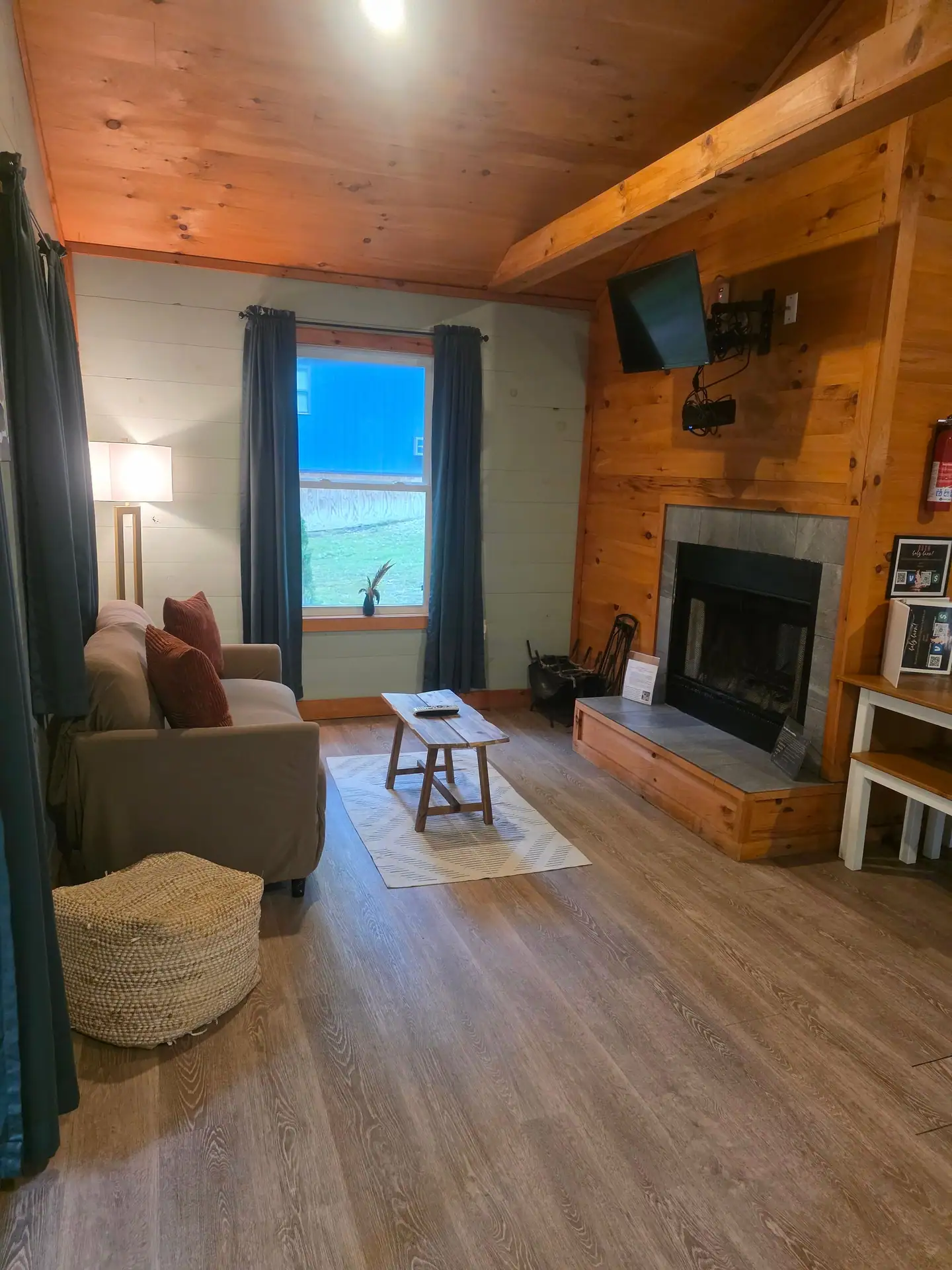 Living room with sofa, coffee table, wall TV and fireplace at Dogwood Run cabin