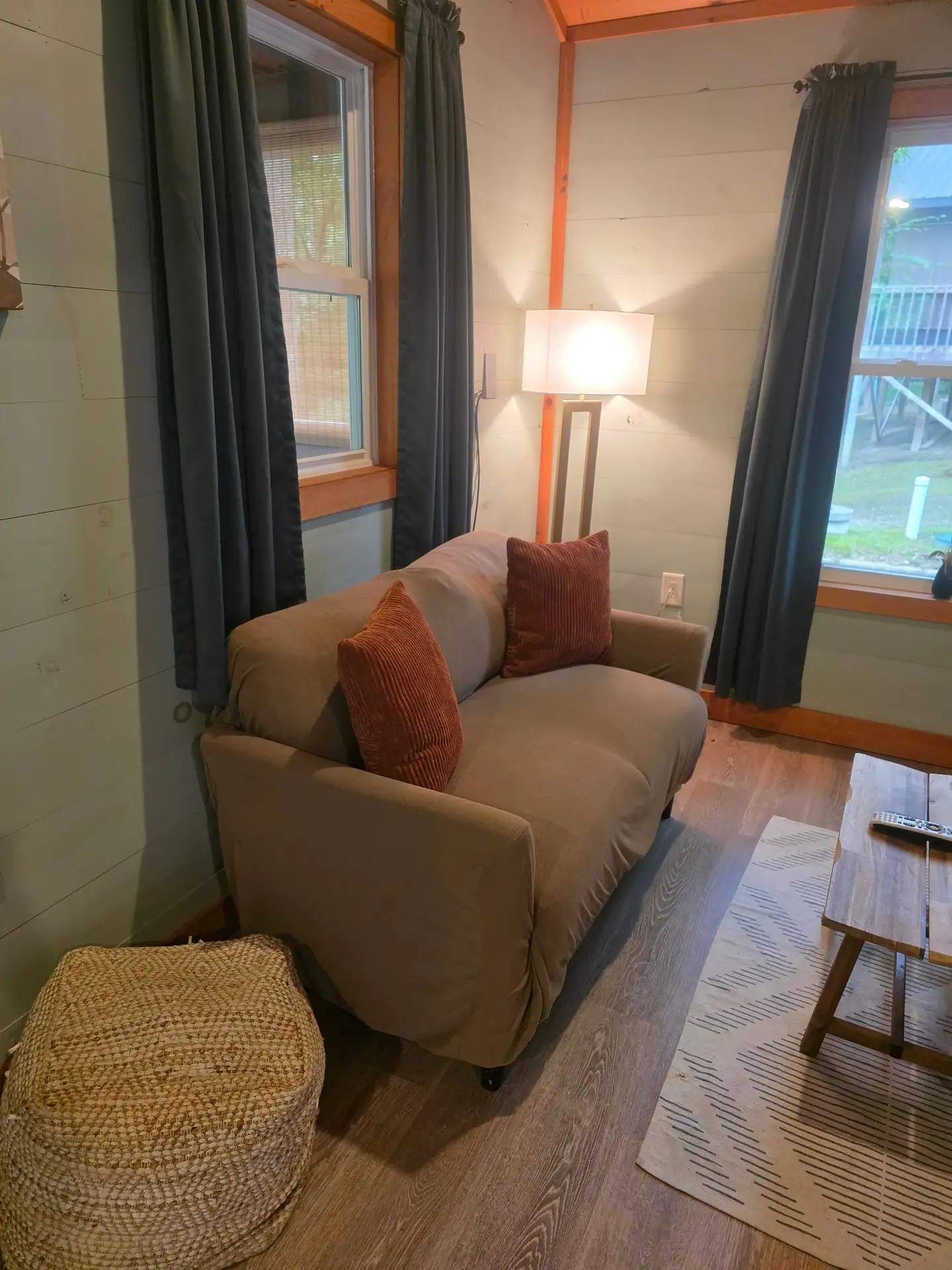 Sofa with throw pillows, pouf and floor lamp in the living room at Dogwood Run cabin
