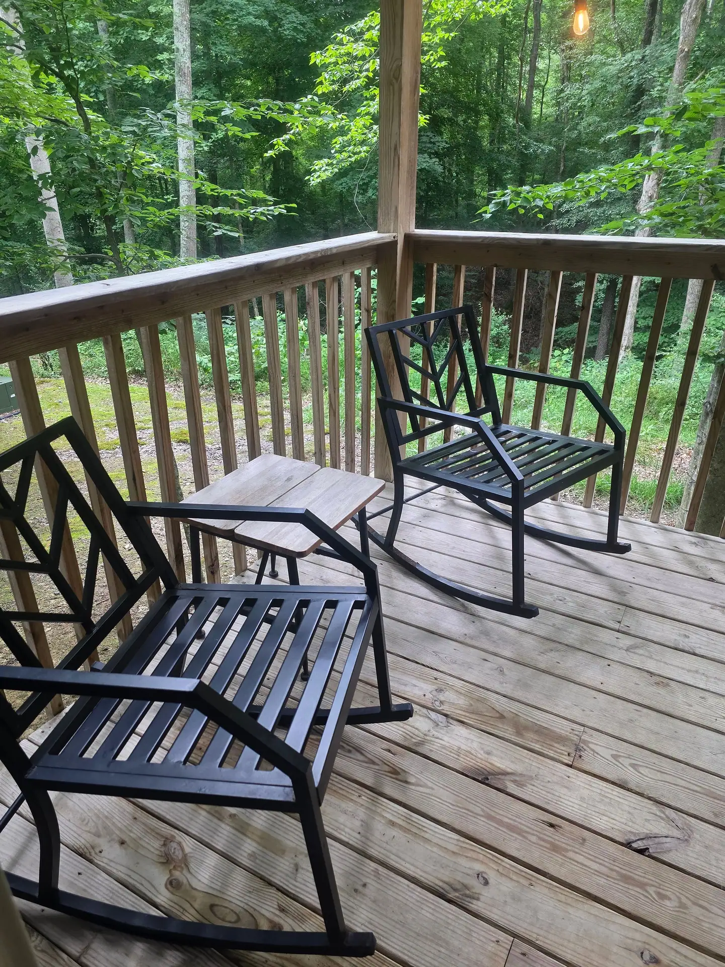 Covered deck with two rocking chairs overlooking the forest at Dogwood Run cabin