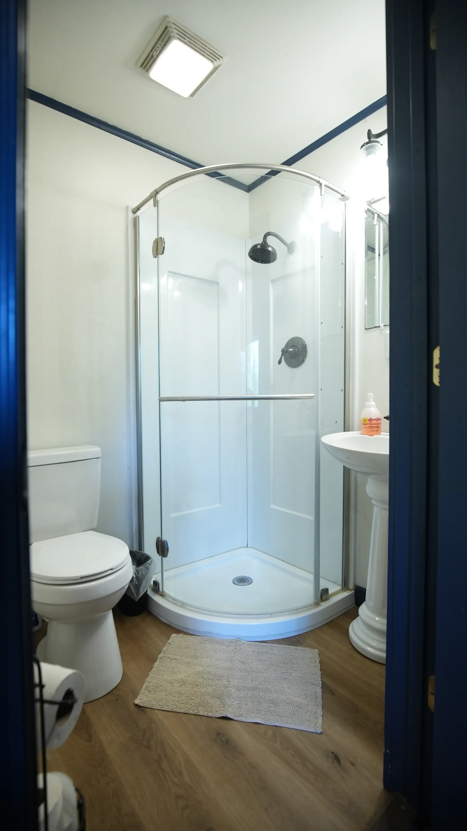 Clean bathroom with curved glass shower enclosure and toilet in Eagles Nest cabin