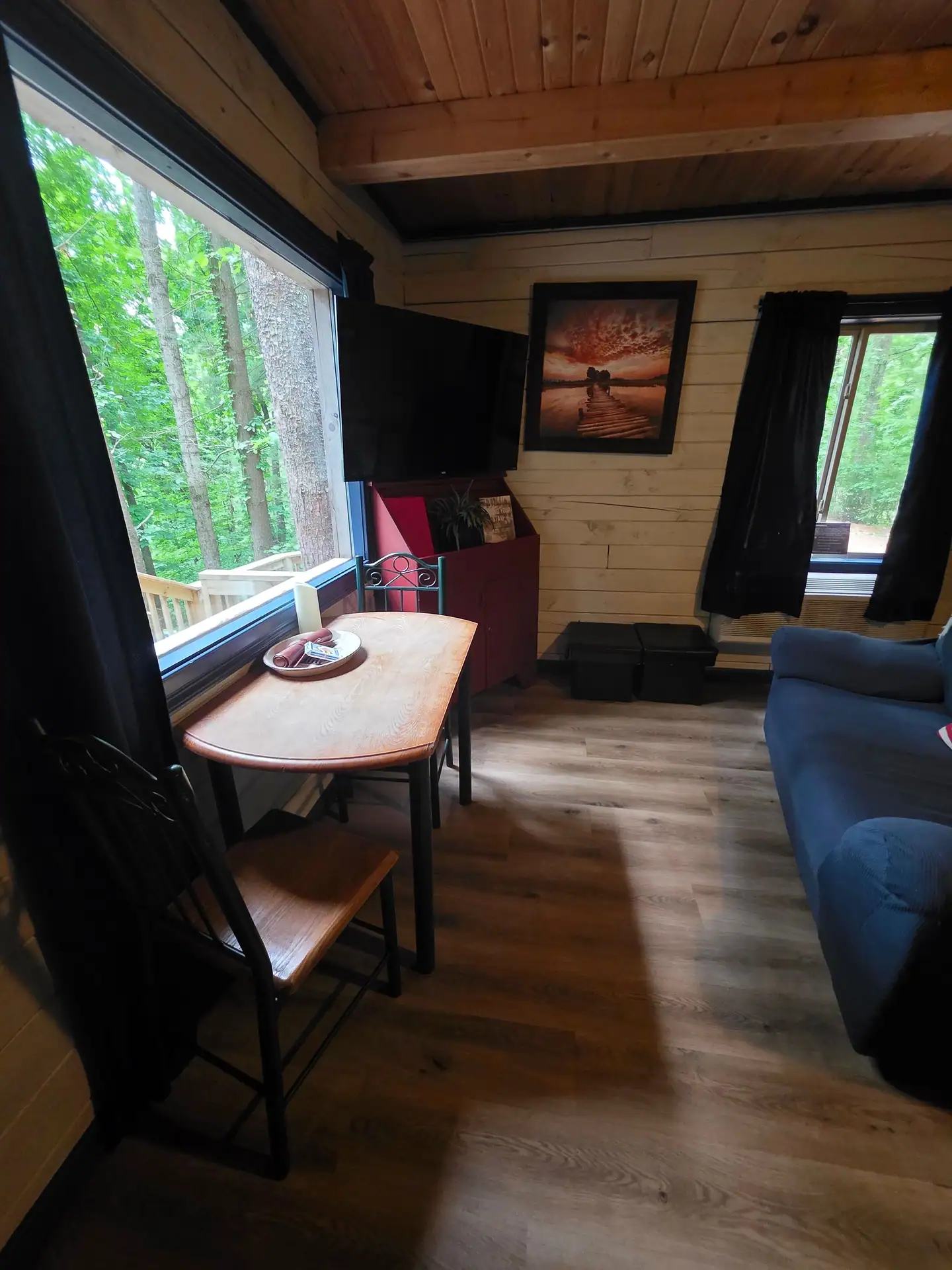 Small dining table beside a forest-view window in the Eagles Nest cabin living room
