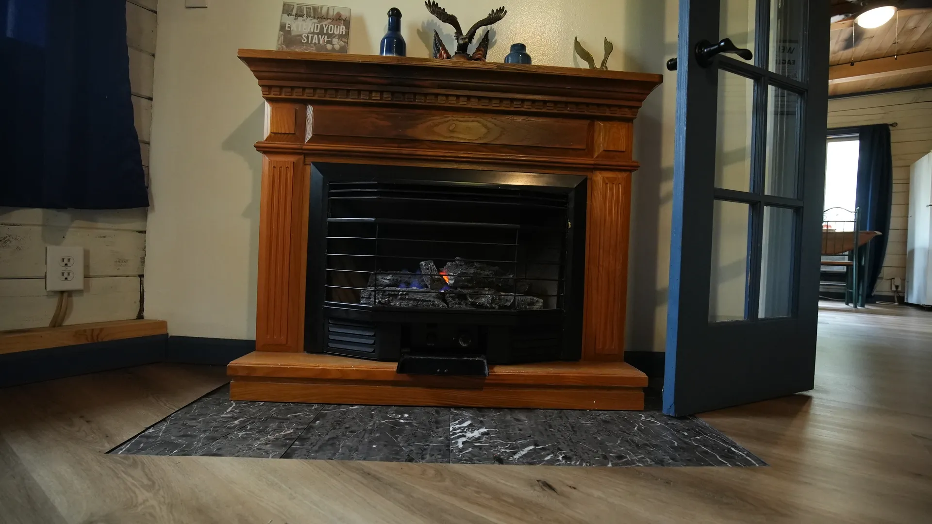 Classic wood-surround fireplace in Eagles Nest cabin living room with rustic decor