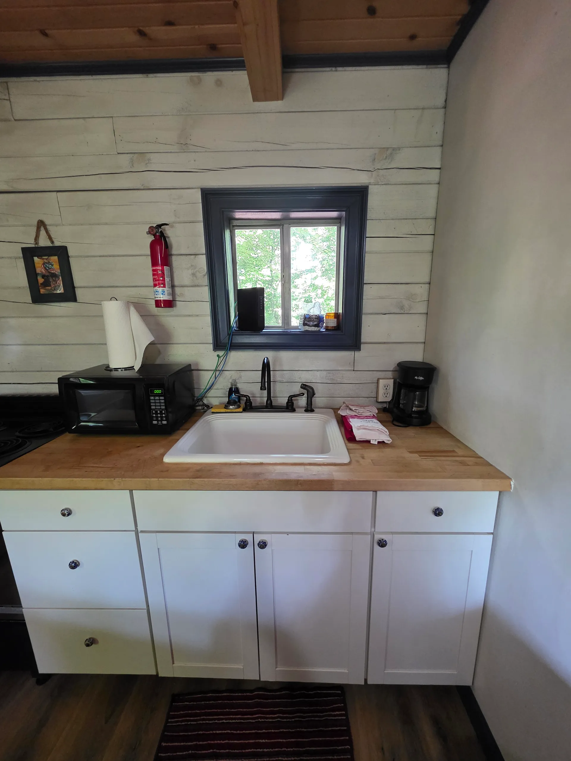 Eagles Nest cabin kitchen with white cabinets, farmhouse sink, and butcher block countertop