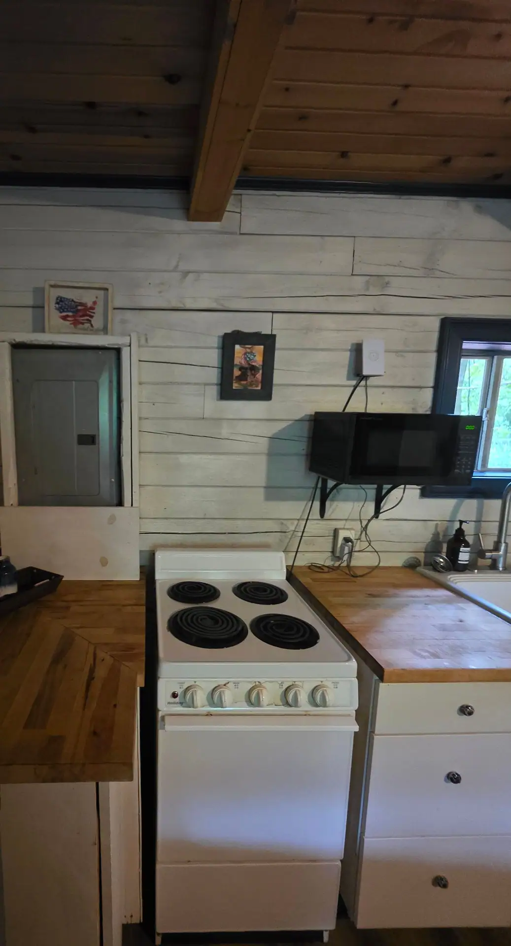 Electric stove, microwave and butcher block counters in the Eagles Nest cabin kitchen