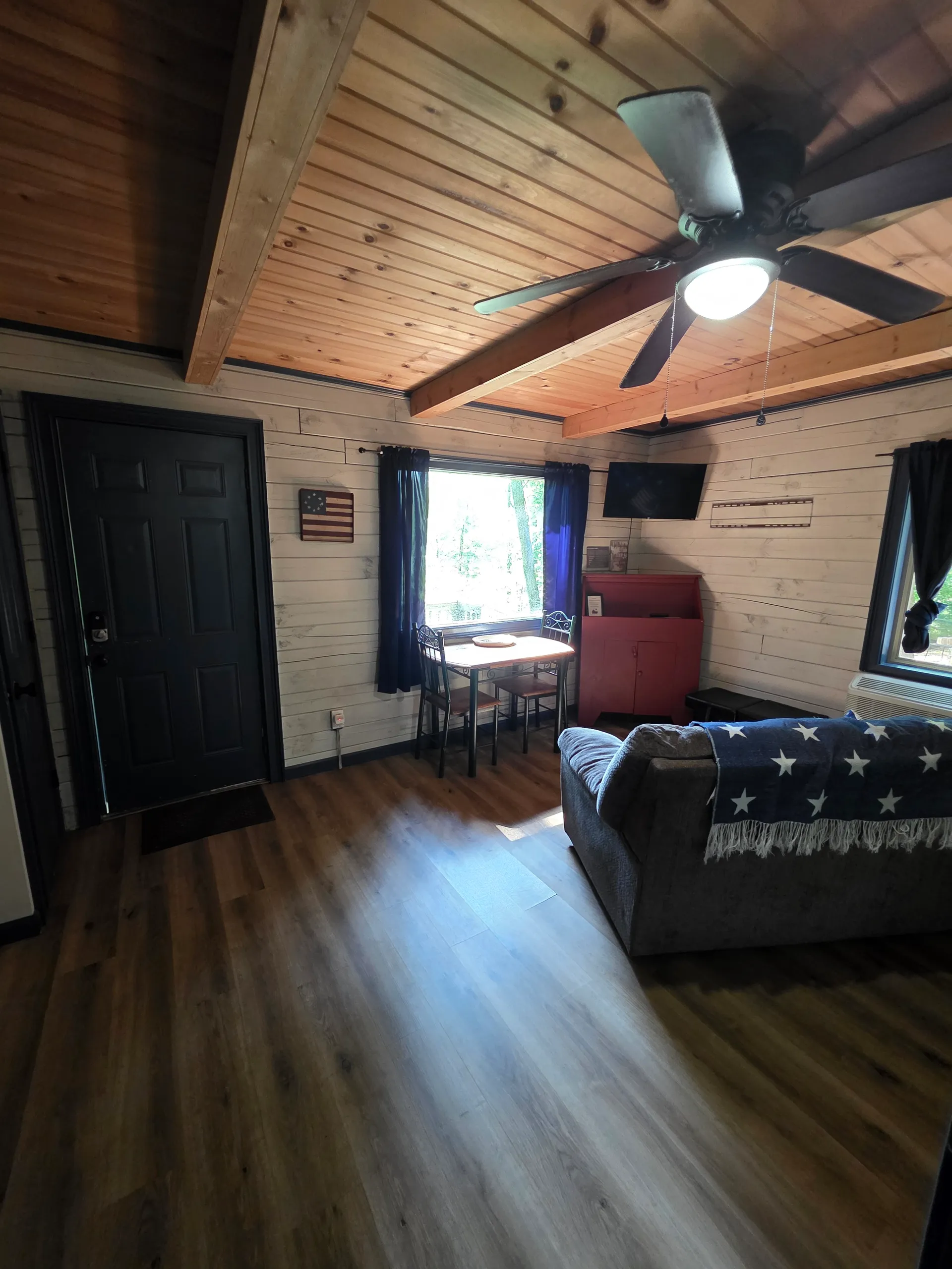 Eagles Nest cabin cozy living room with vaulted wood ceiling, sofa, and natural light