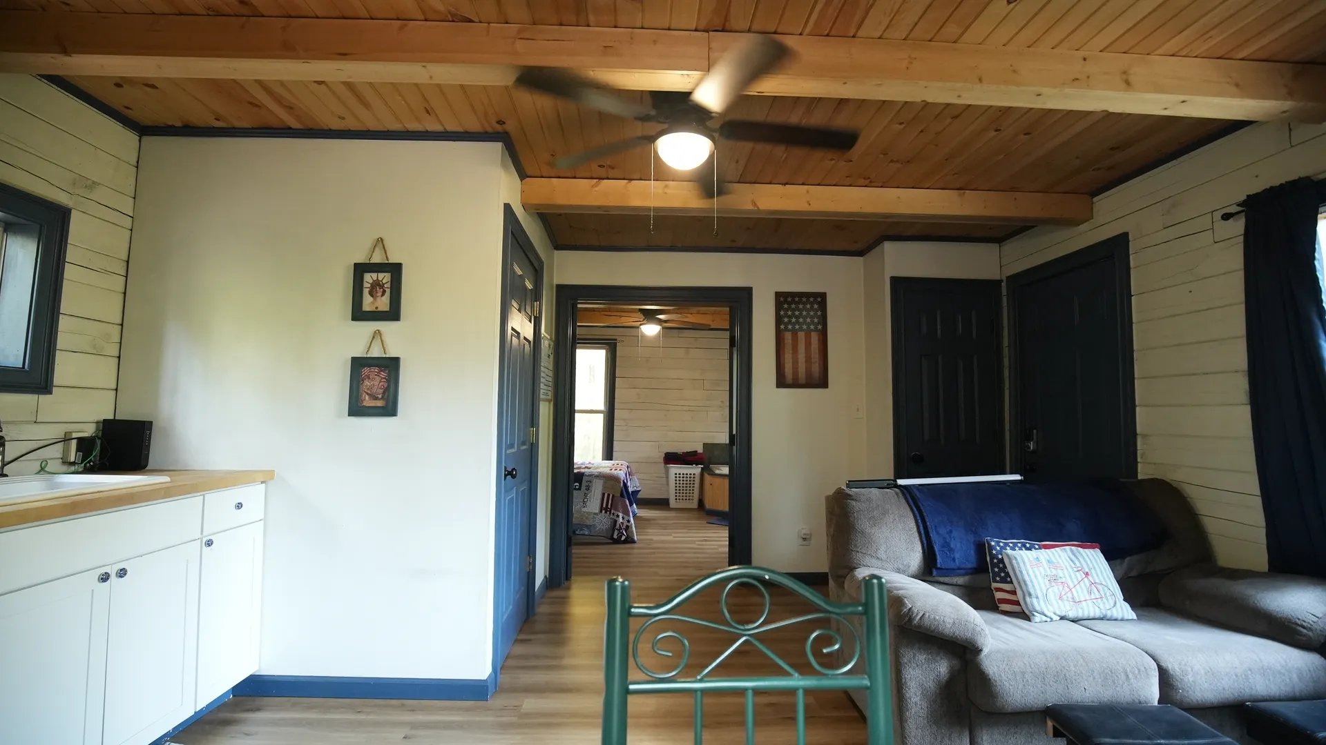 Eagles Nest cabin lower level open living area with kitchenette, sofa, and wood beam ceiling