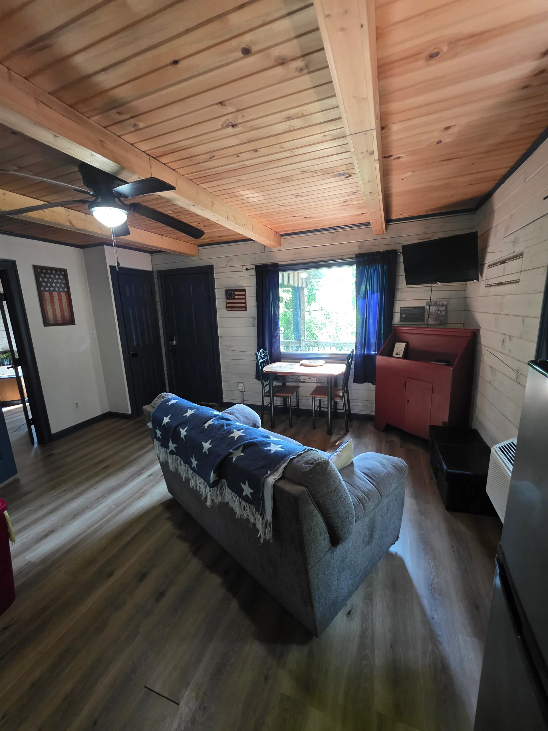 Open floor plan living area with sofa, recliner, and vaulted wood paneled ceiling in Eagles Nest cabin