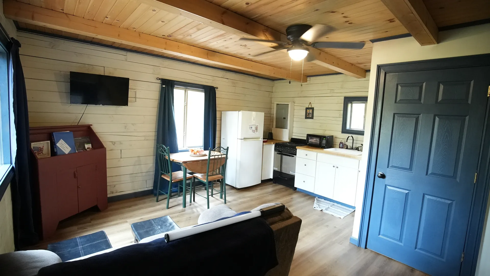 Eagles Nest cabin open concept living room with kitchen, dining table, and wall-mounted TV