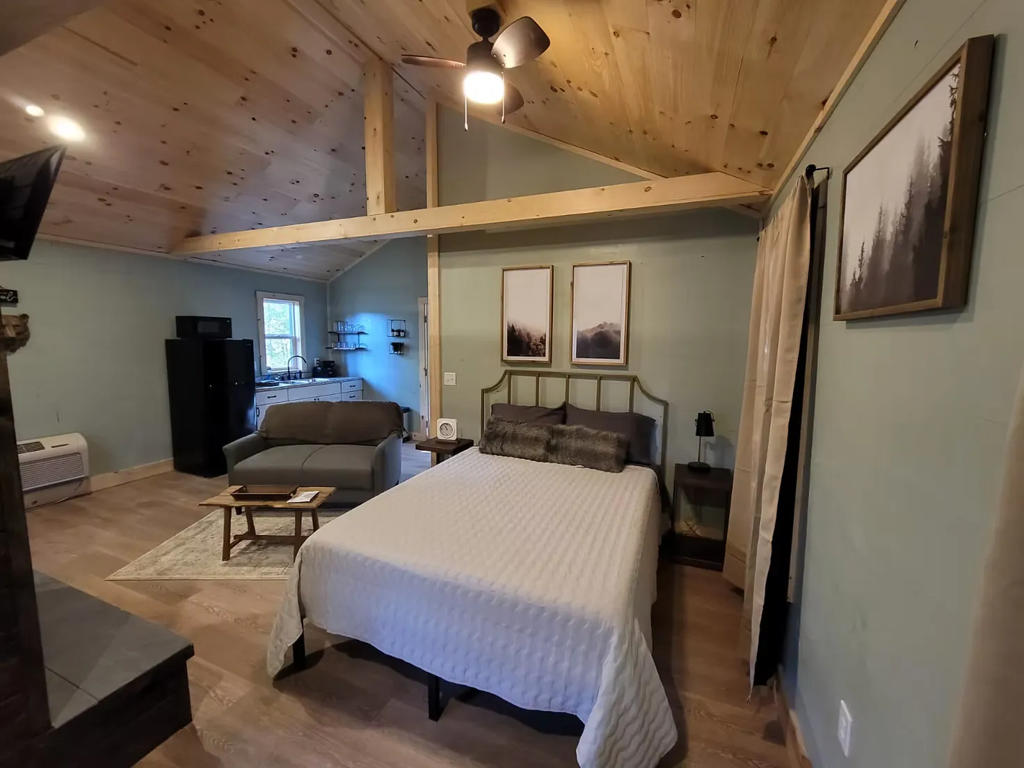 Covered deck with hot tub and forest surroundings at Firefly cabin