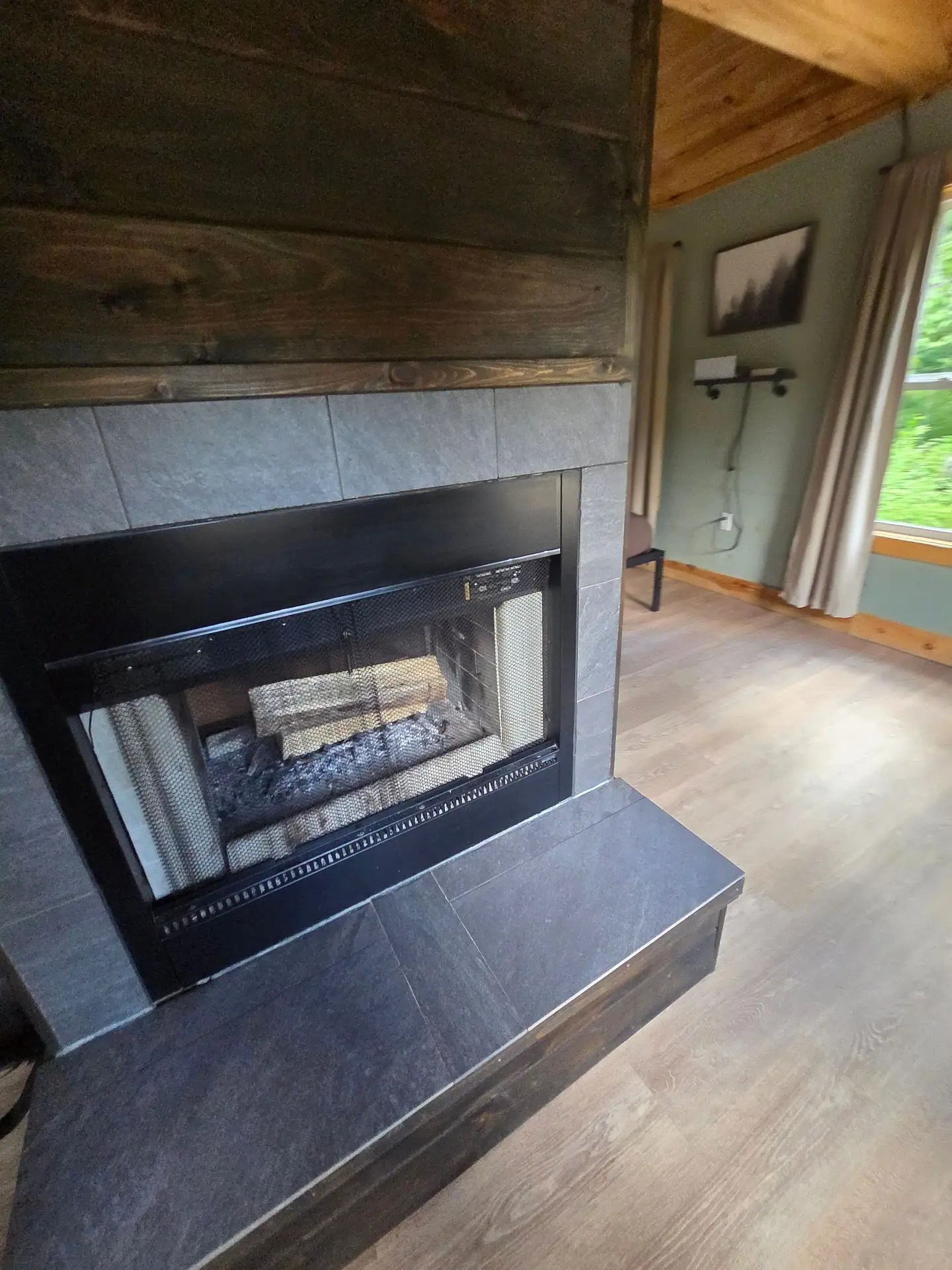 Wood-burning fireplace with tile surround and raised hearth at Firefly's Landing
