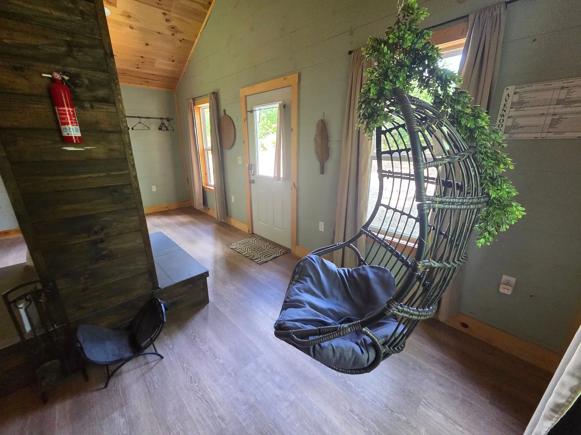 Hanging egg chair with greenery beside the entry door at Firefly's Landing