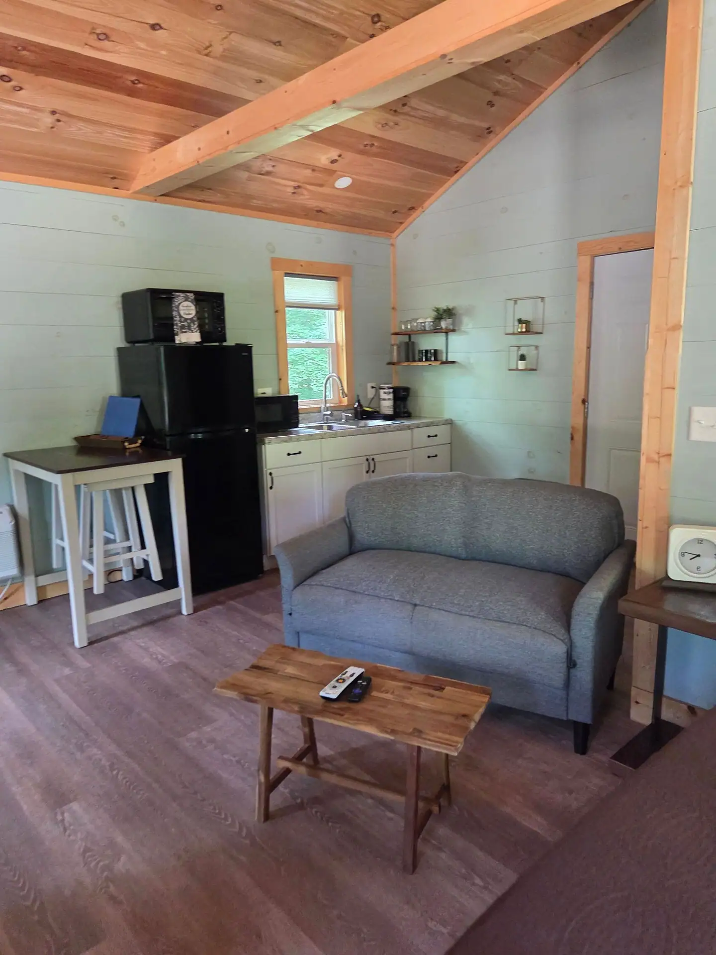 Gray loveseat and wooden coffee table beside the kitchenette at Firefly's Landing