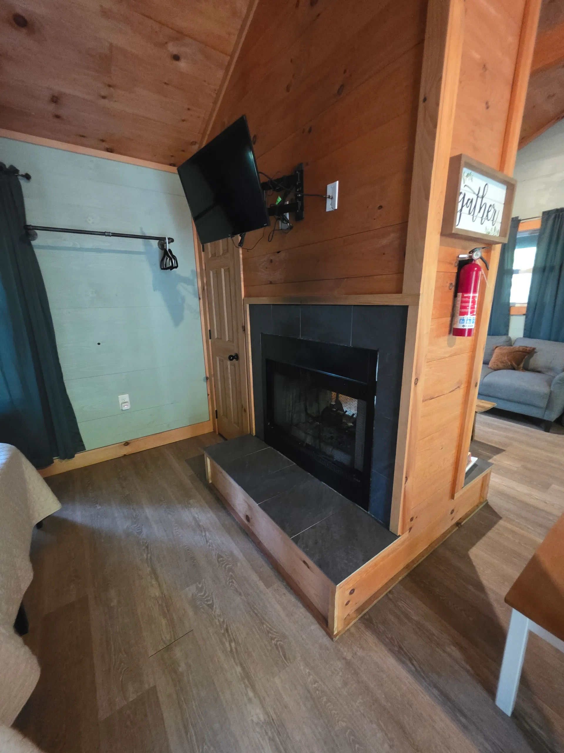 Wood and slate fireplace with fire extinguisher and decor at Forest Aisle cabin
