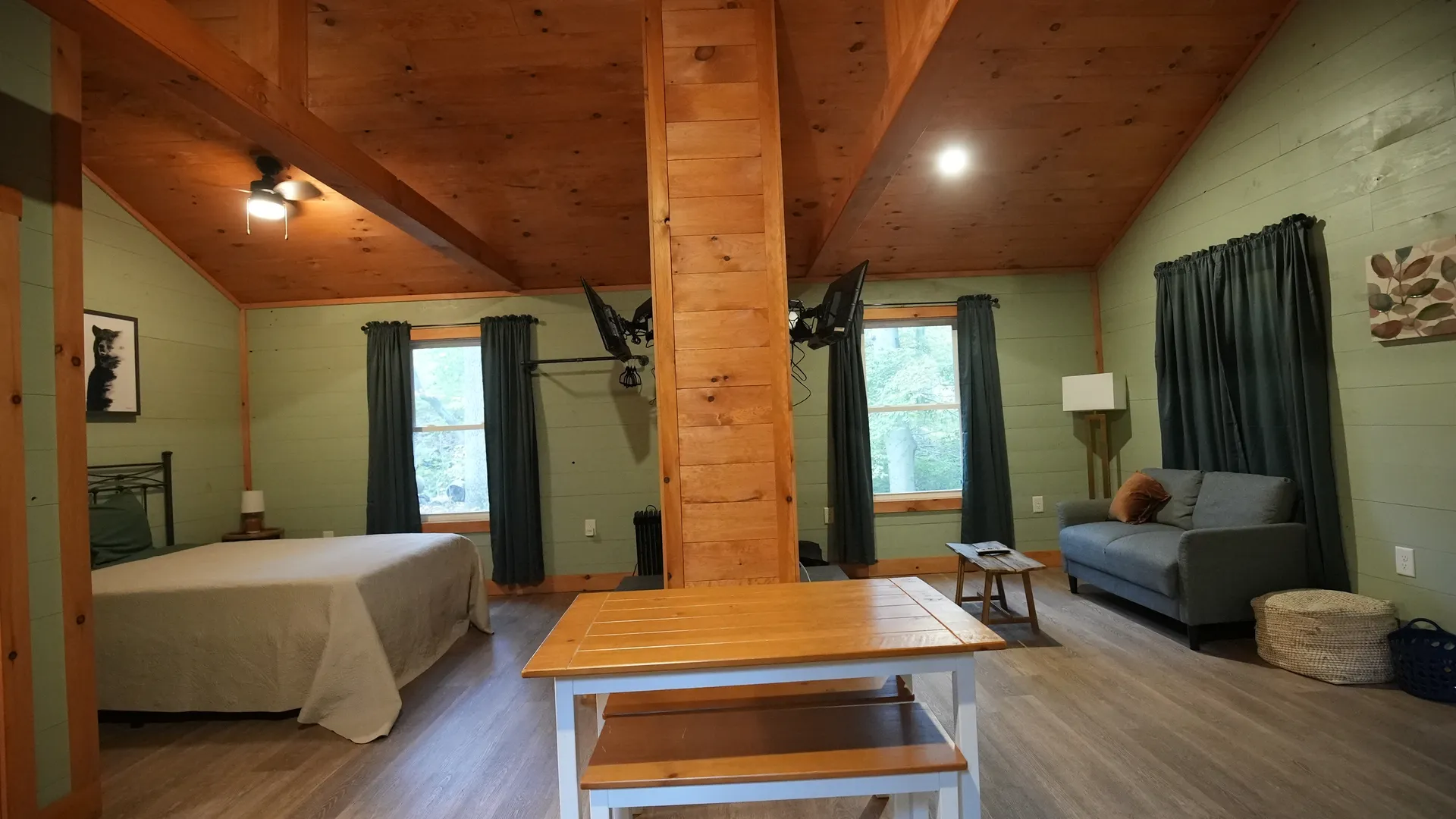 Wide interior view with bedroom, cedar beam, dining area, and living room at Forest Aisle cabin