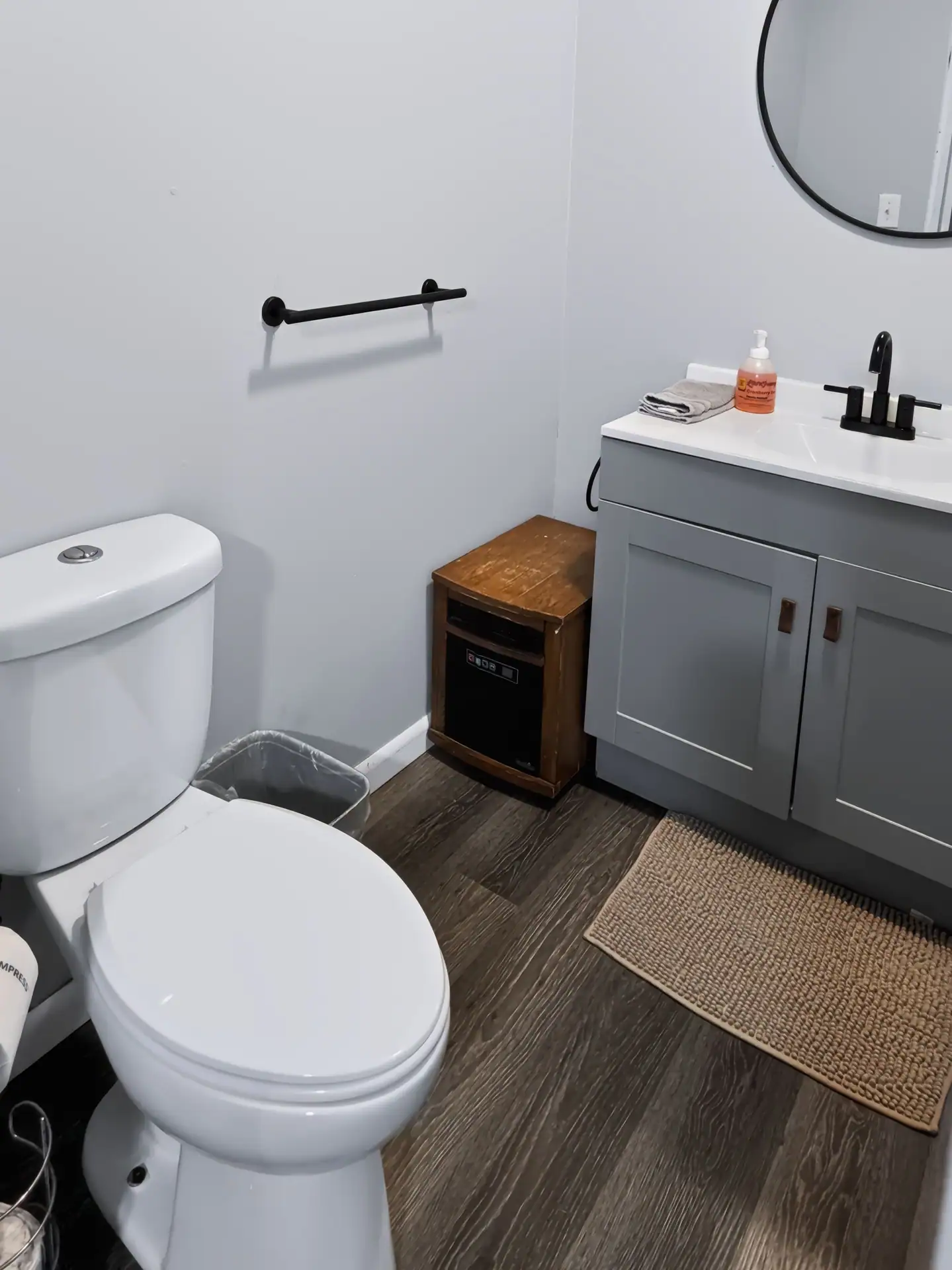 Second bathroom at The Getaway House with a gray vanity and round mirror.