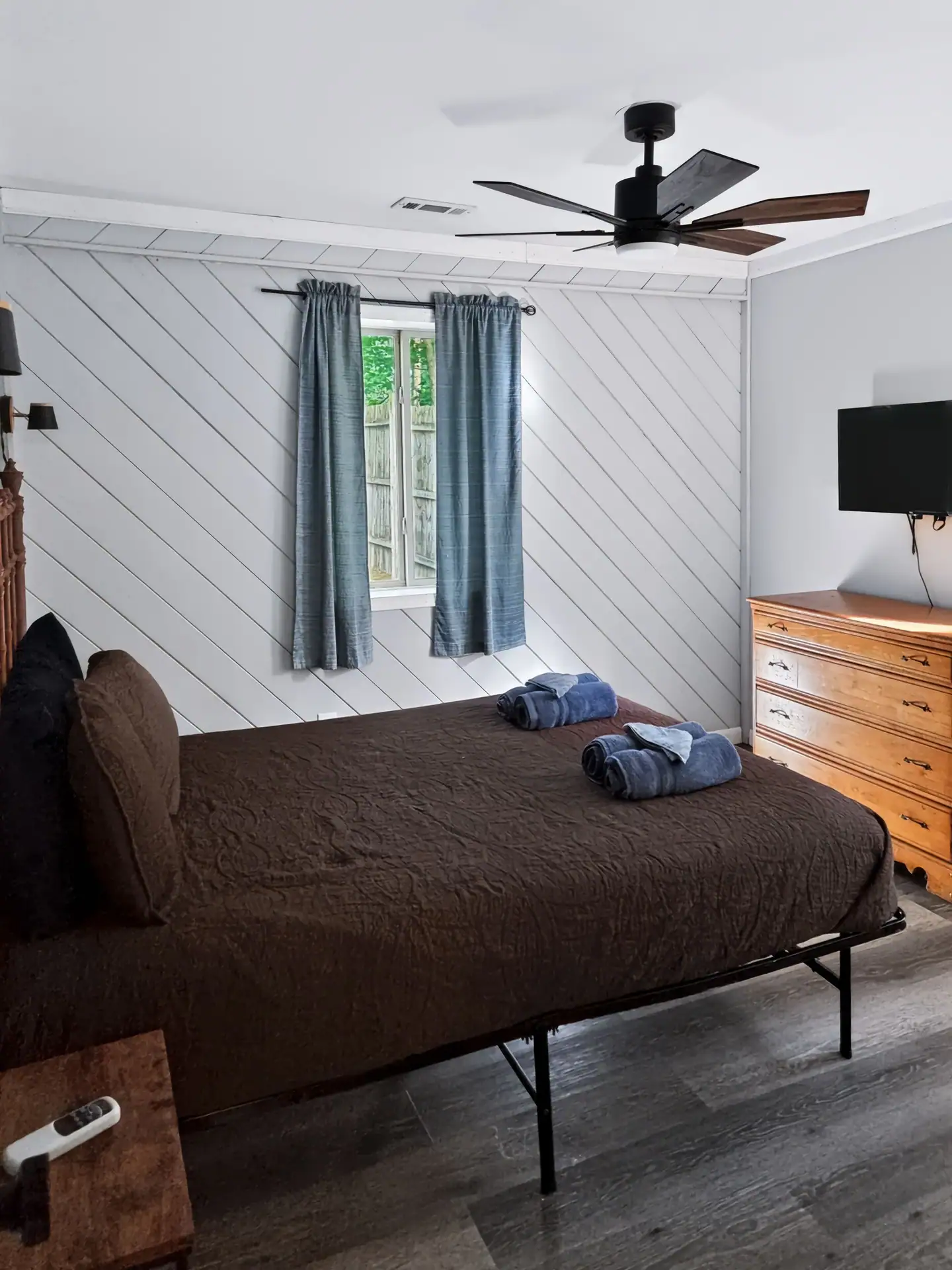 First bedroom of The Getaway House with a dresser, TV and window.