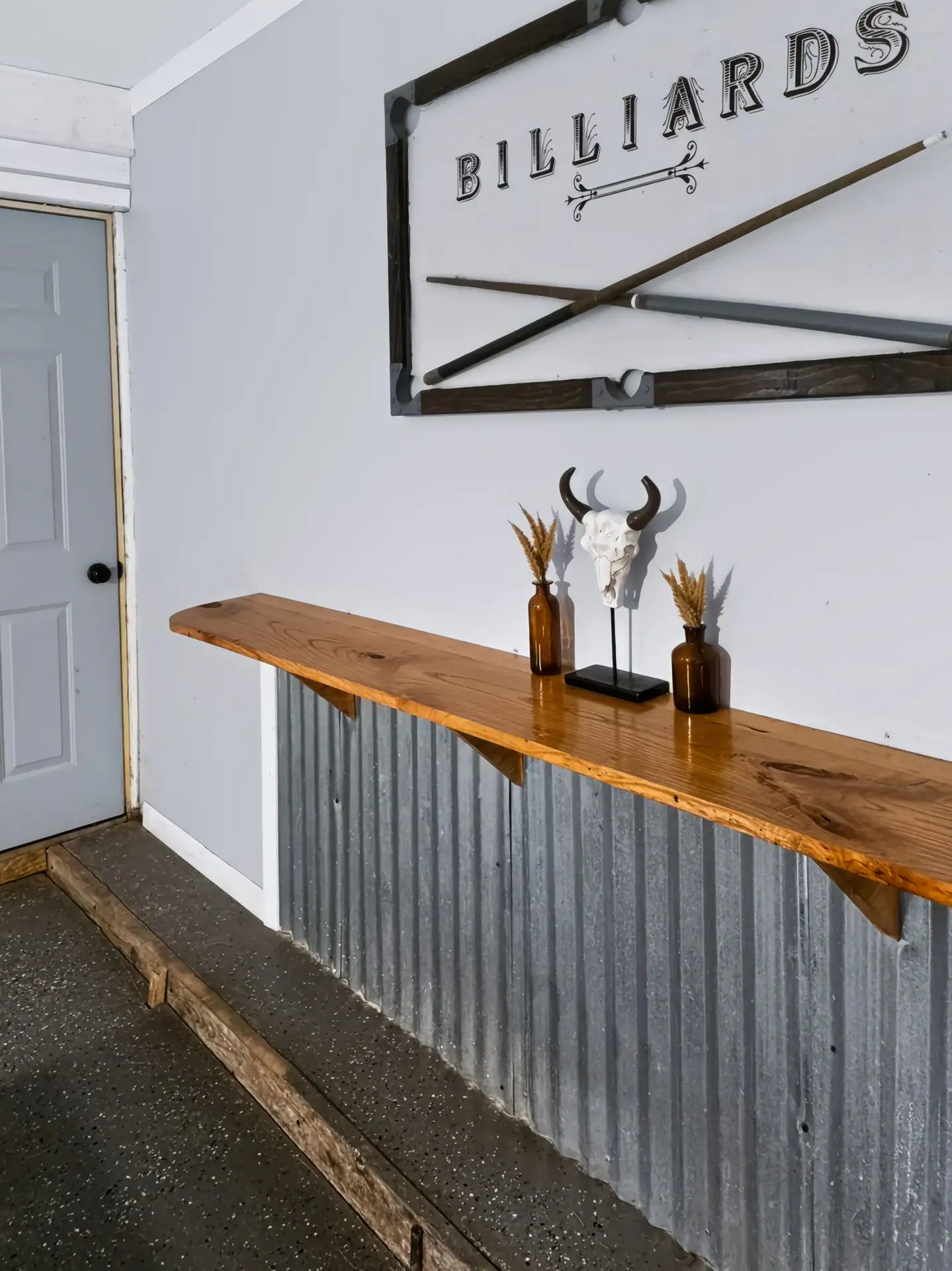 Wood bar ledge with a corrugated metal front in the game room of The Getaway House.