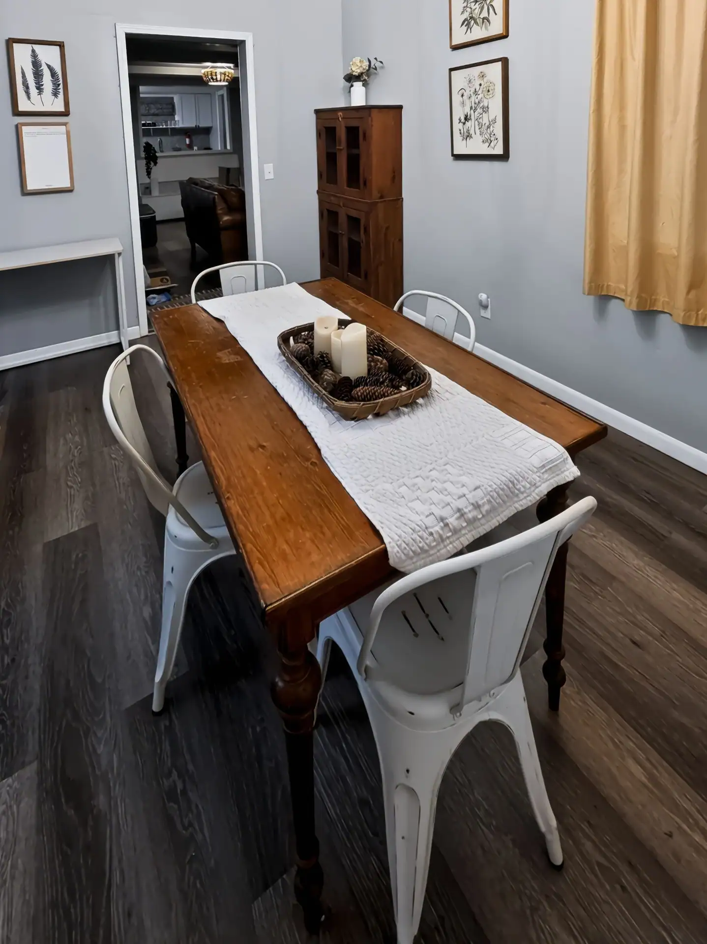 Dining area with a wooden hutch and botanical prints at The Getaway House.