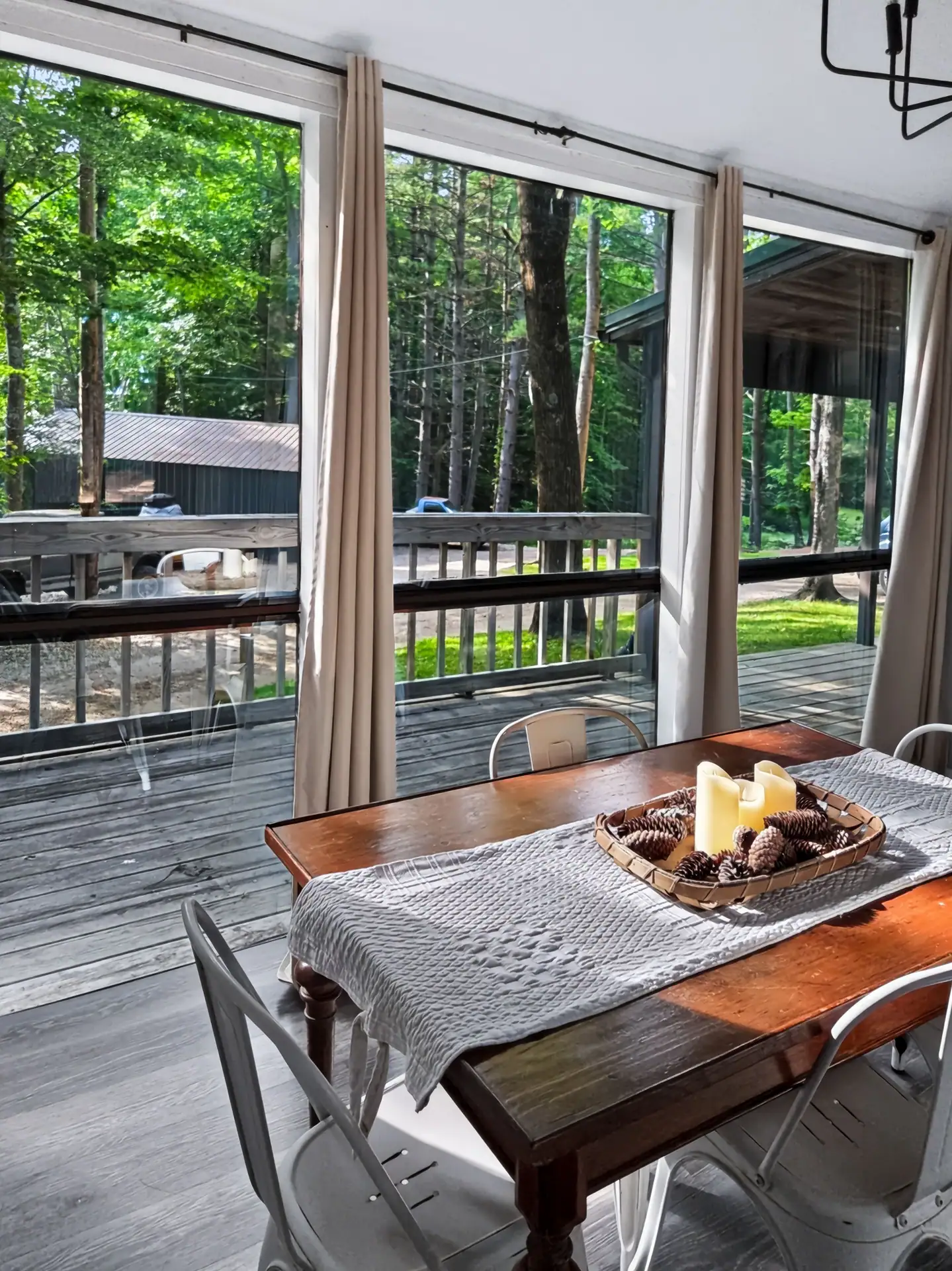 Dining table at The Getaway House with a view through the windows to the deck and woods.