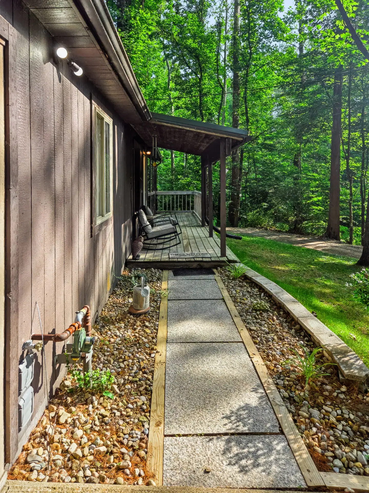Paved walkway with a stone border leading to the front porch of The Getaway House.