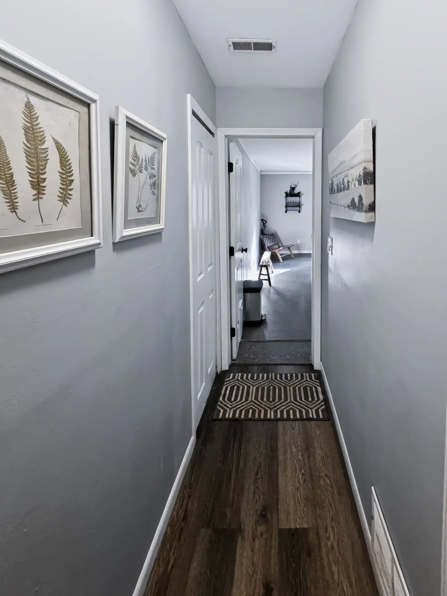Hallway with framed fern prints leading to the bedrooms at The Getaway House.