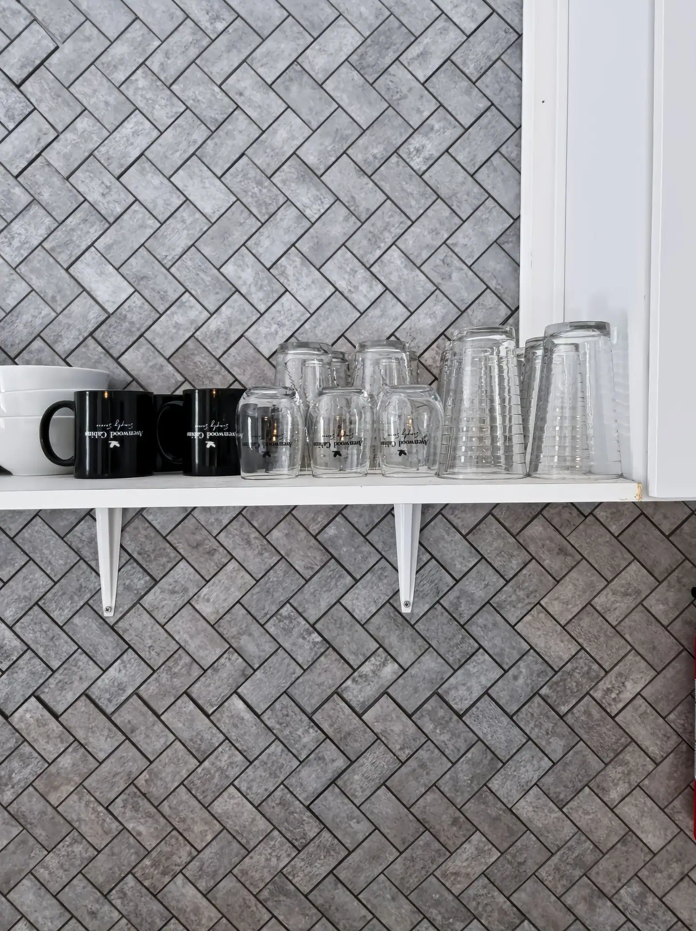 Open shelf with mugs and glasses above the kitchen counter at The Getaway House.