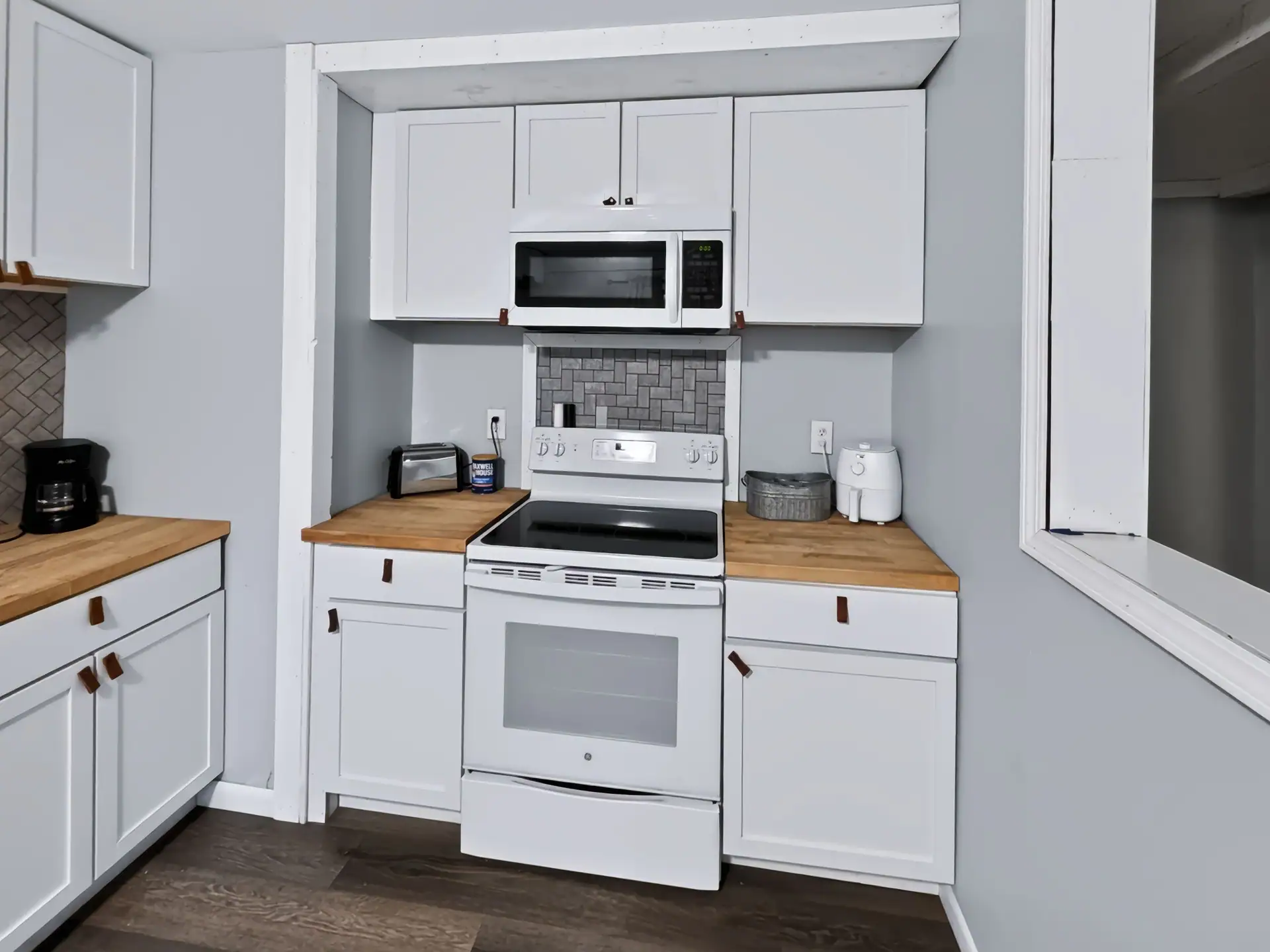 Electric stove, microwave and coffee maker in the full kitchen of The Getaway House.