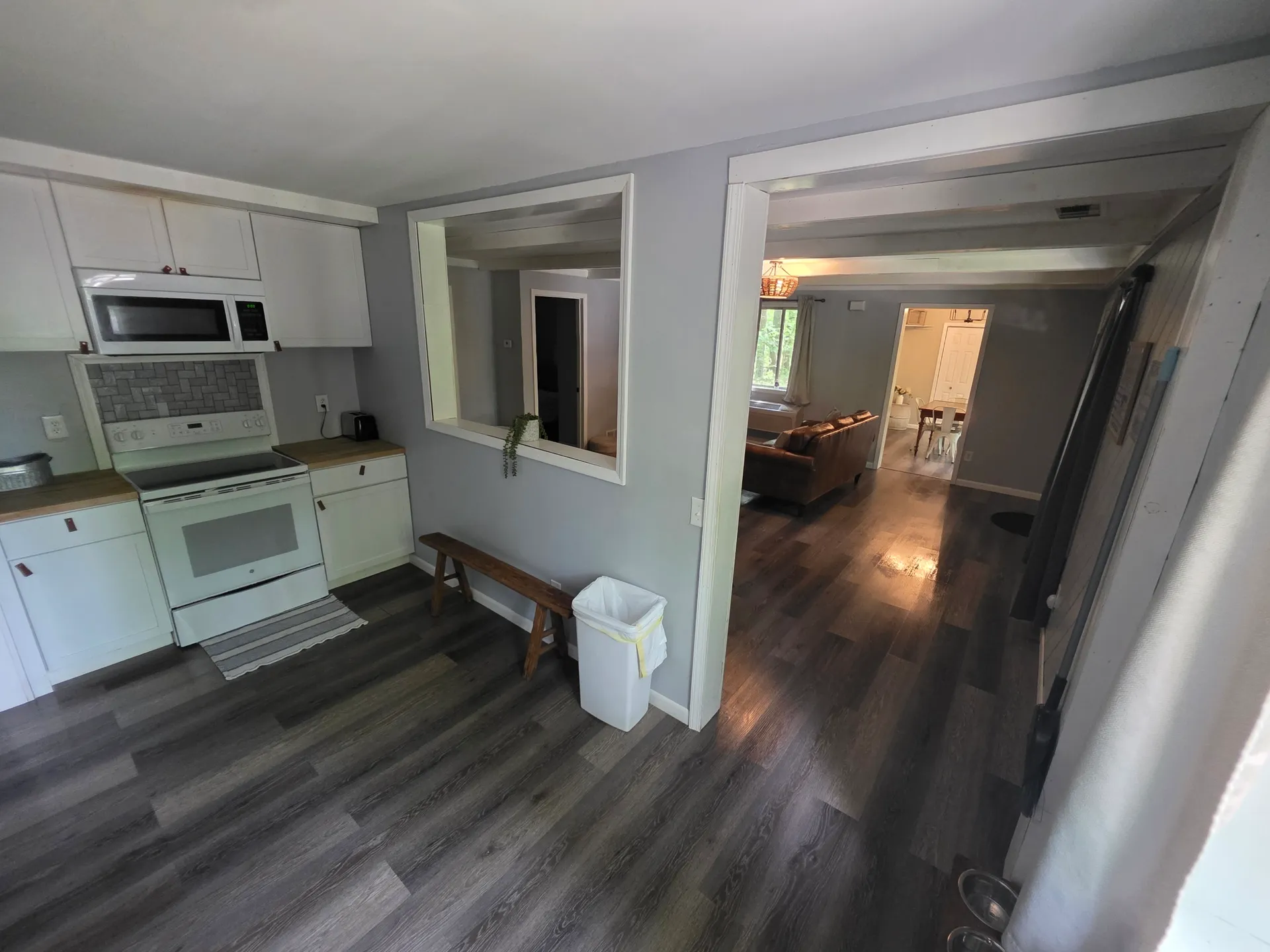 View from kitchen through pass-through to living room and dining area at Getaway House cabin